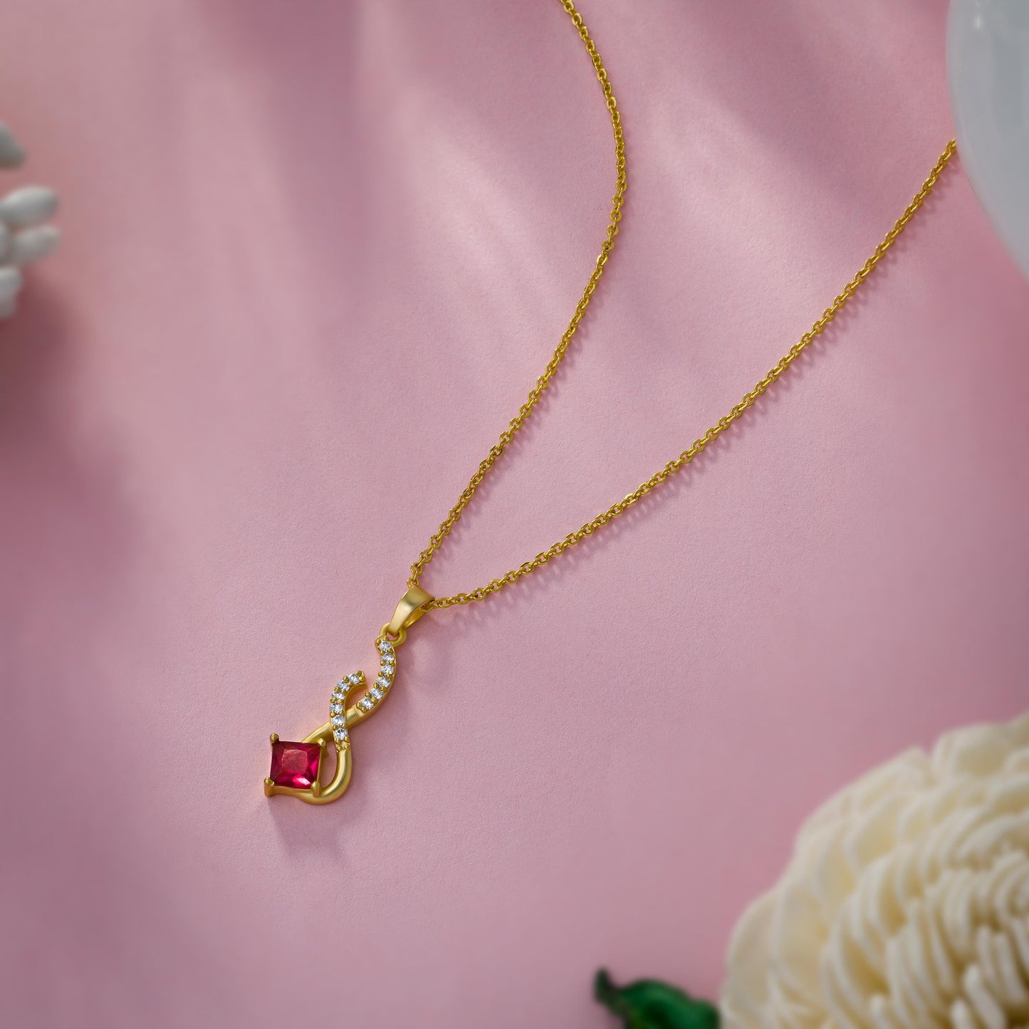 golden necklace with a red stone pendant