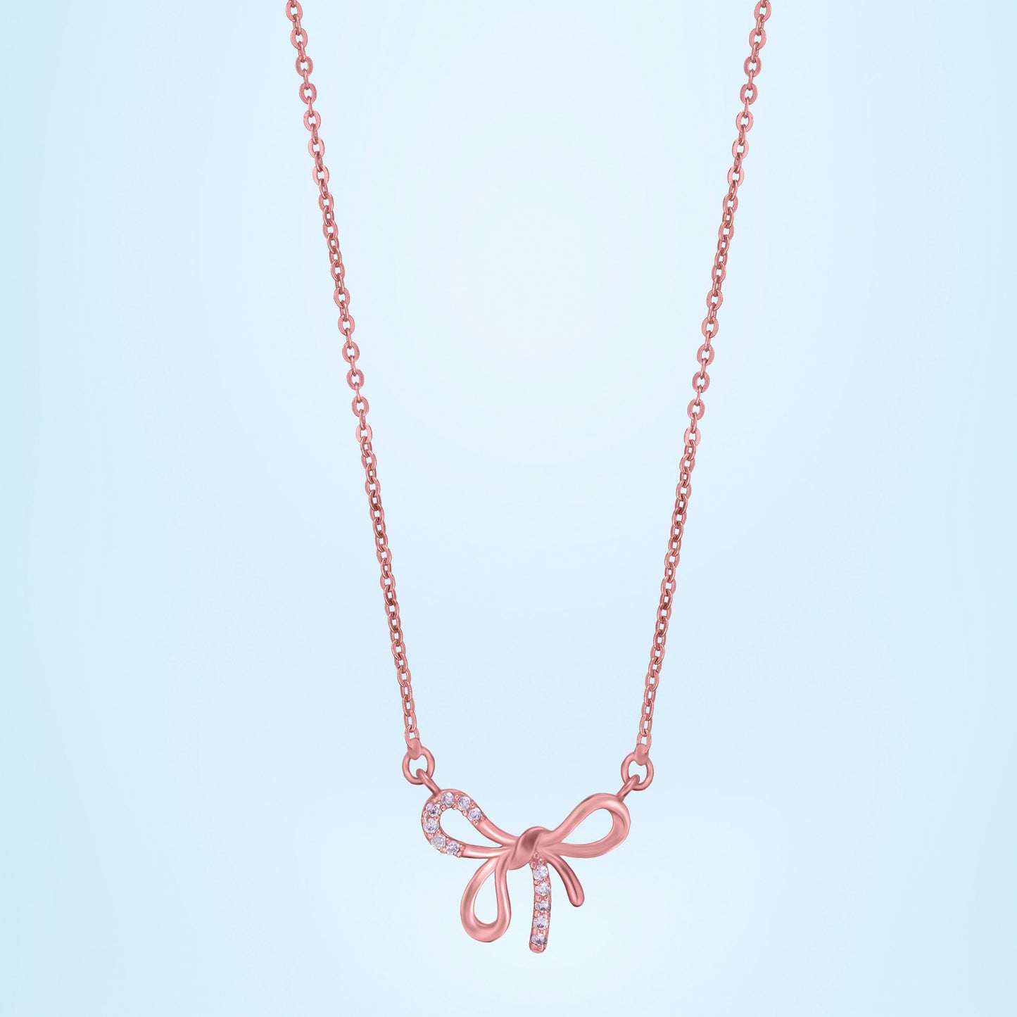 rose gold necklace with a bow on it