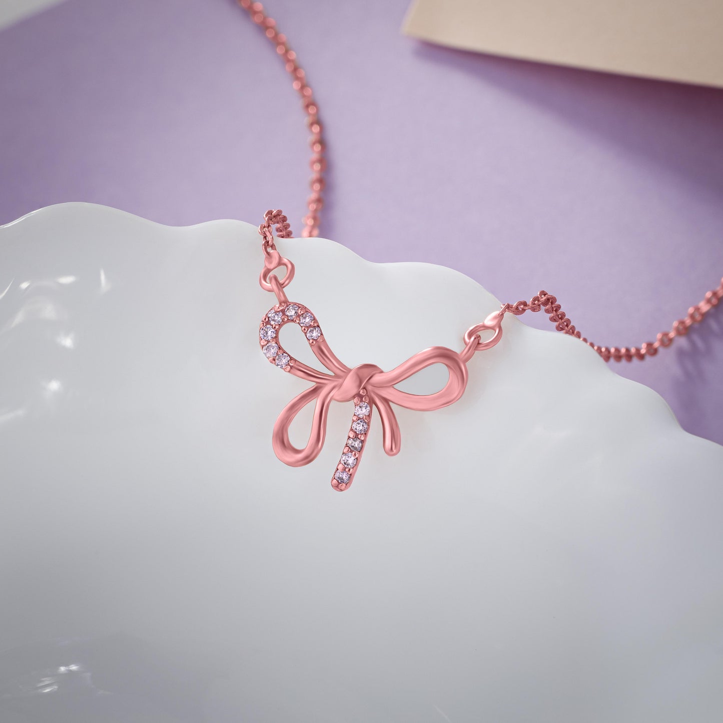 rose gold necklace with a bow on it