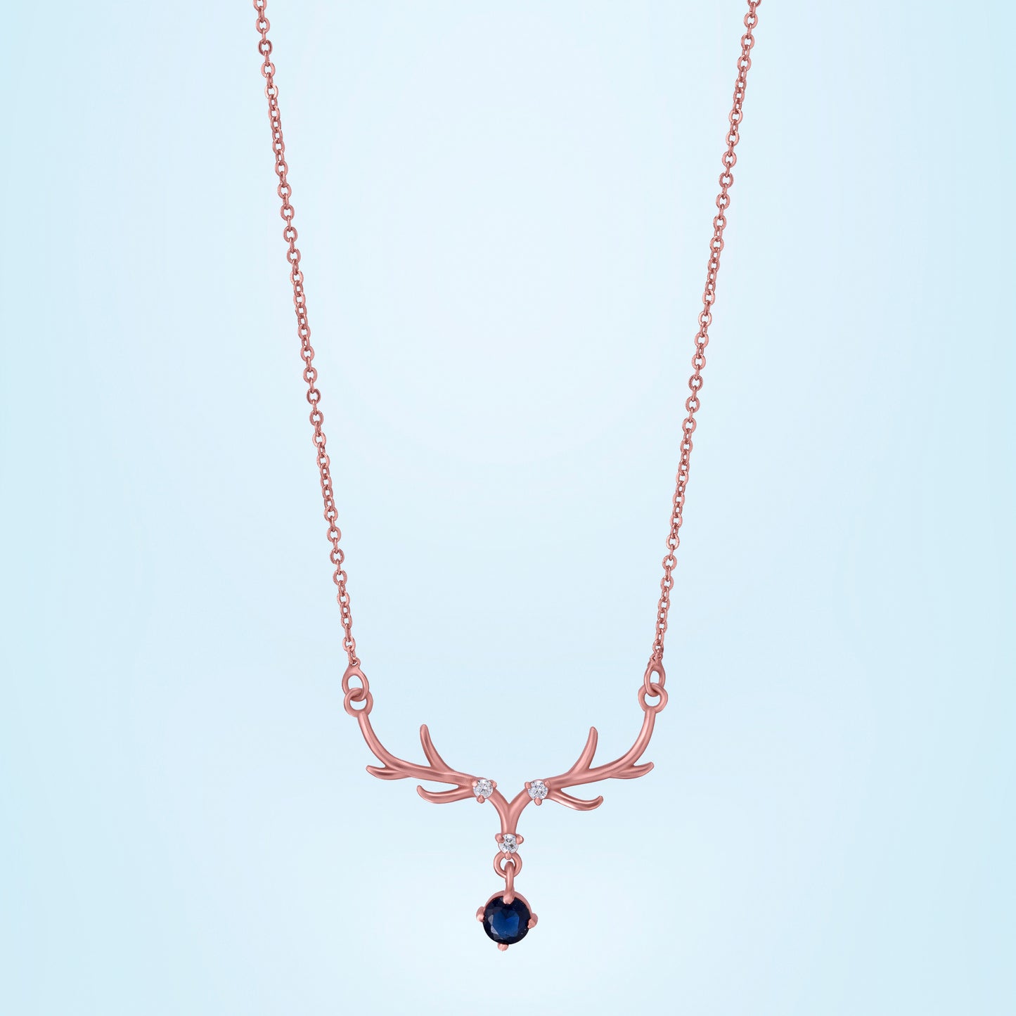 rose gold necklace with a sapphire stone