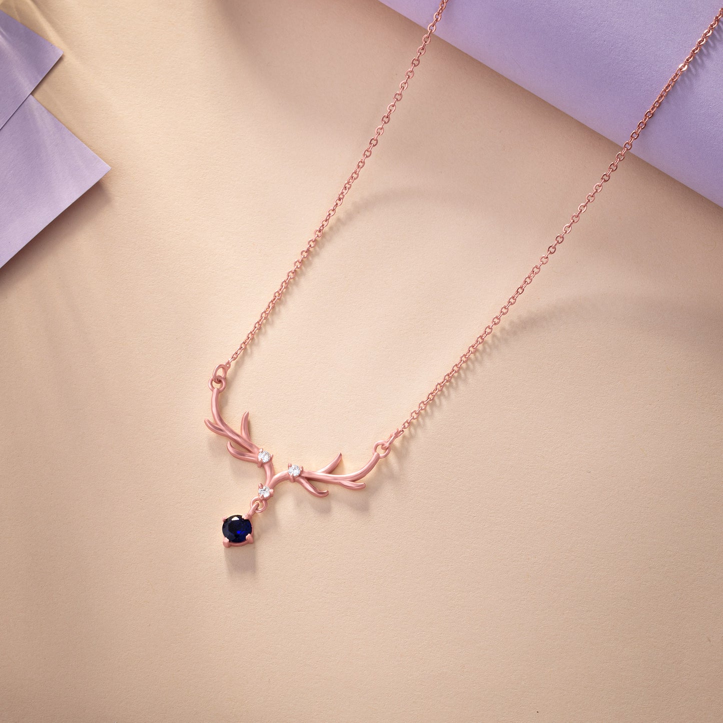 rose gold necklace with a sapphire stone