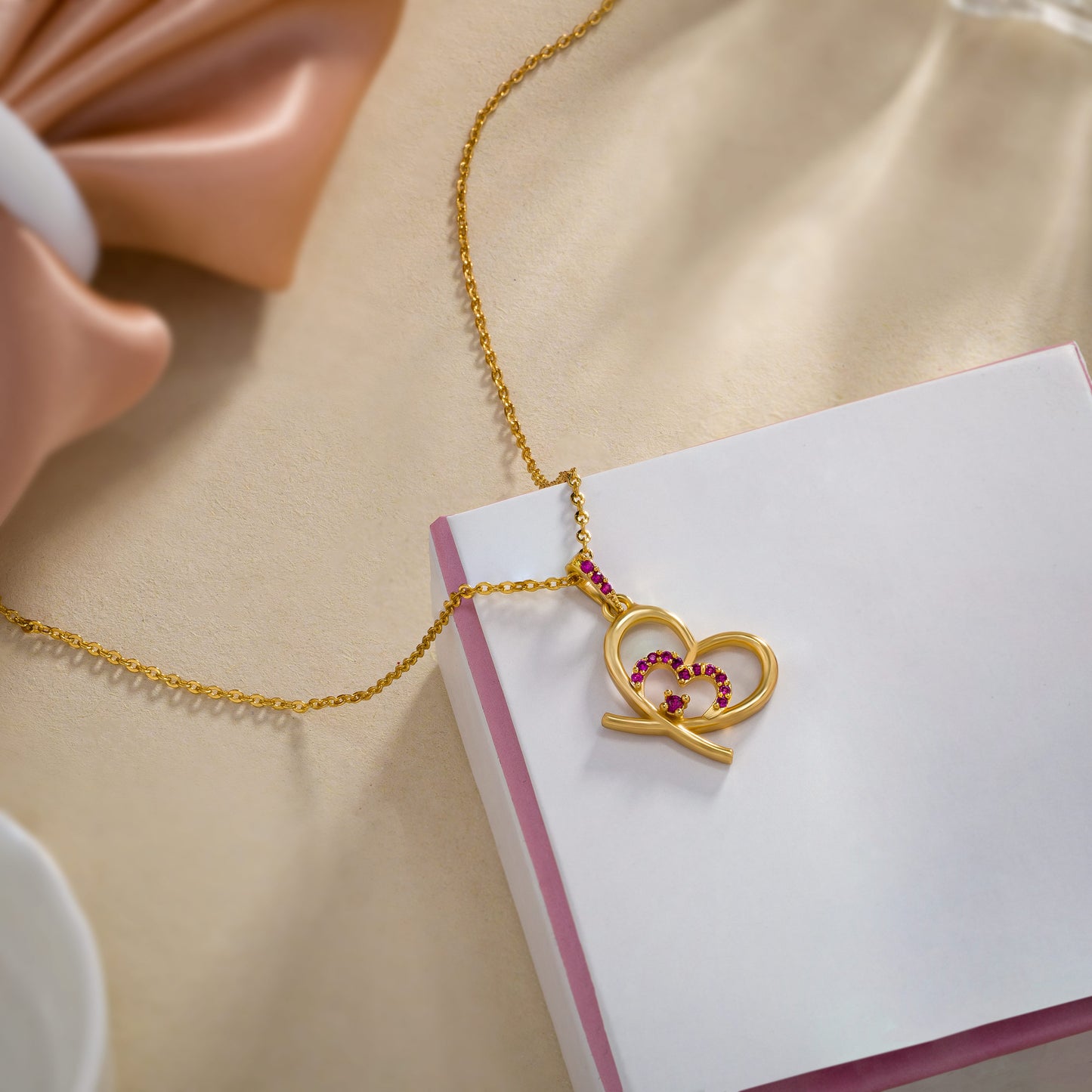 golden heart necklace adorned with pink stones