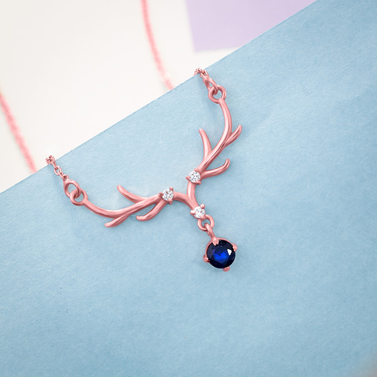 rose gold necklace with a sapphire stone