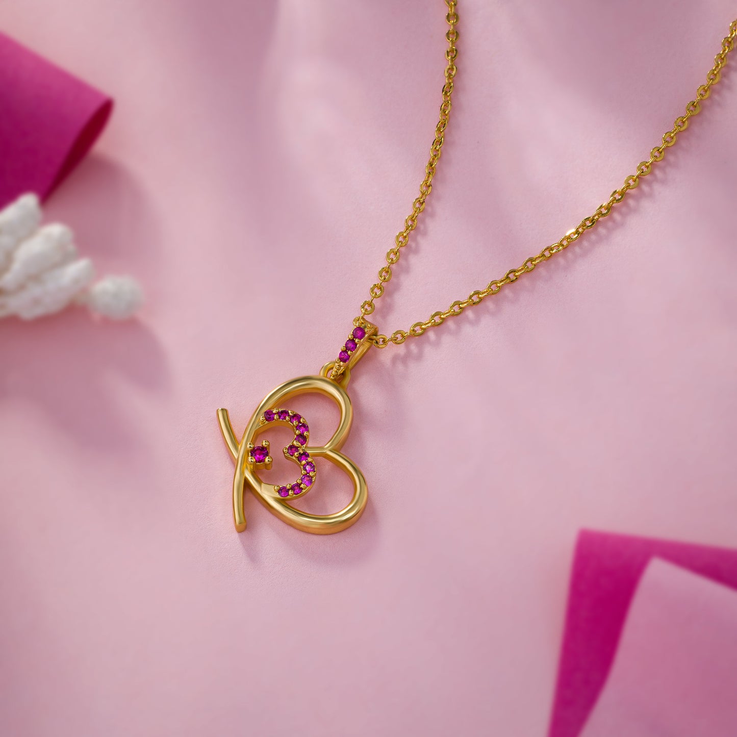 golden heart necklace adorned with pink stones