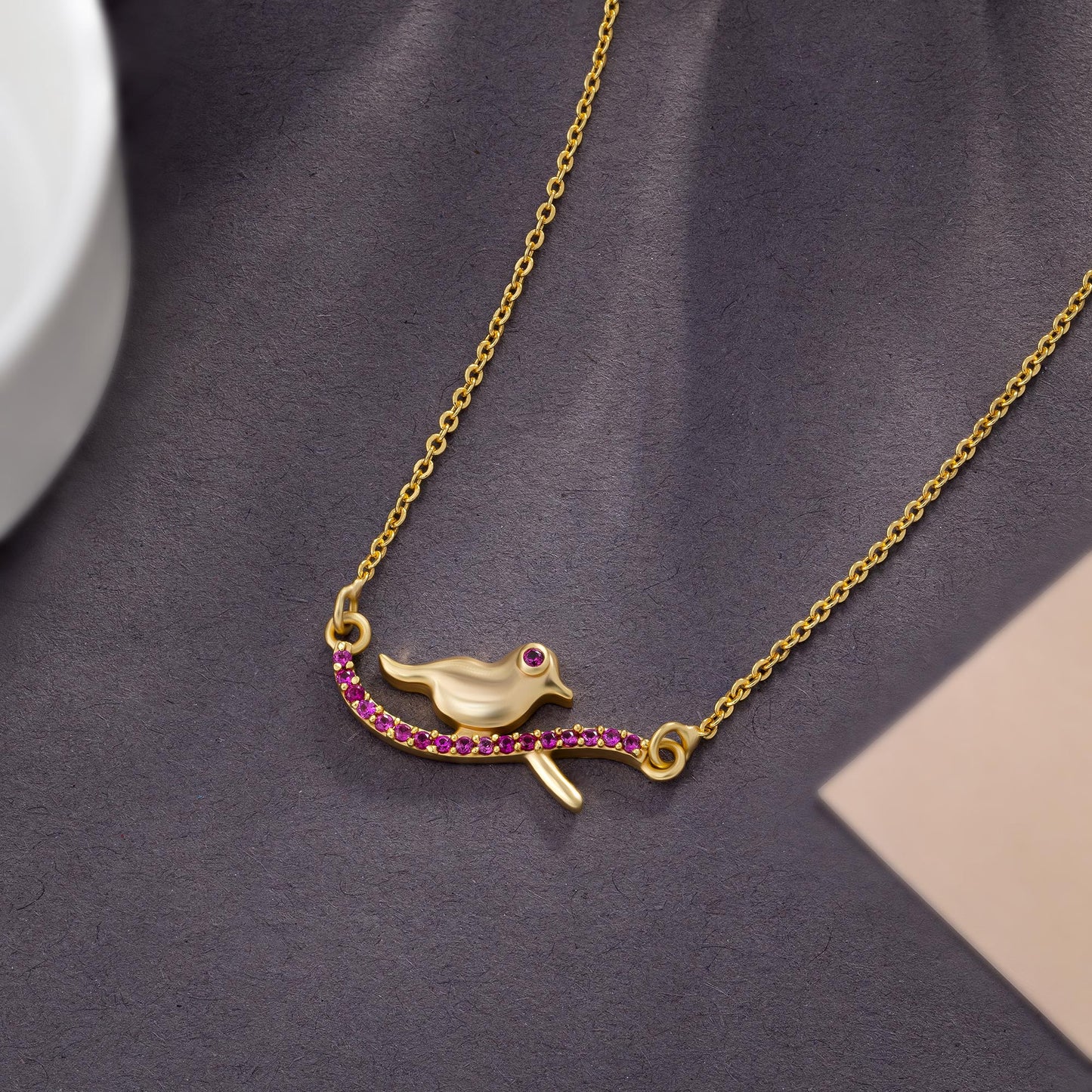 golden bird necklace with pink stones