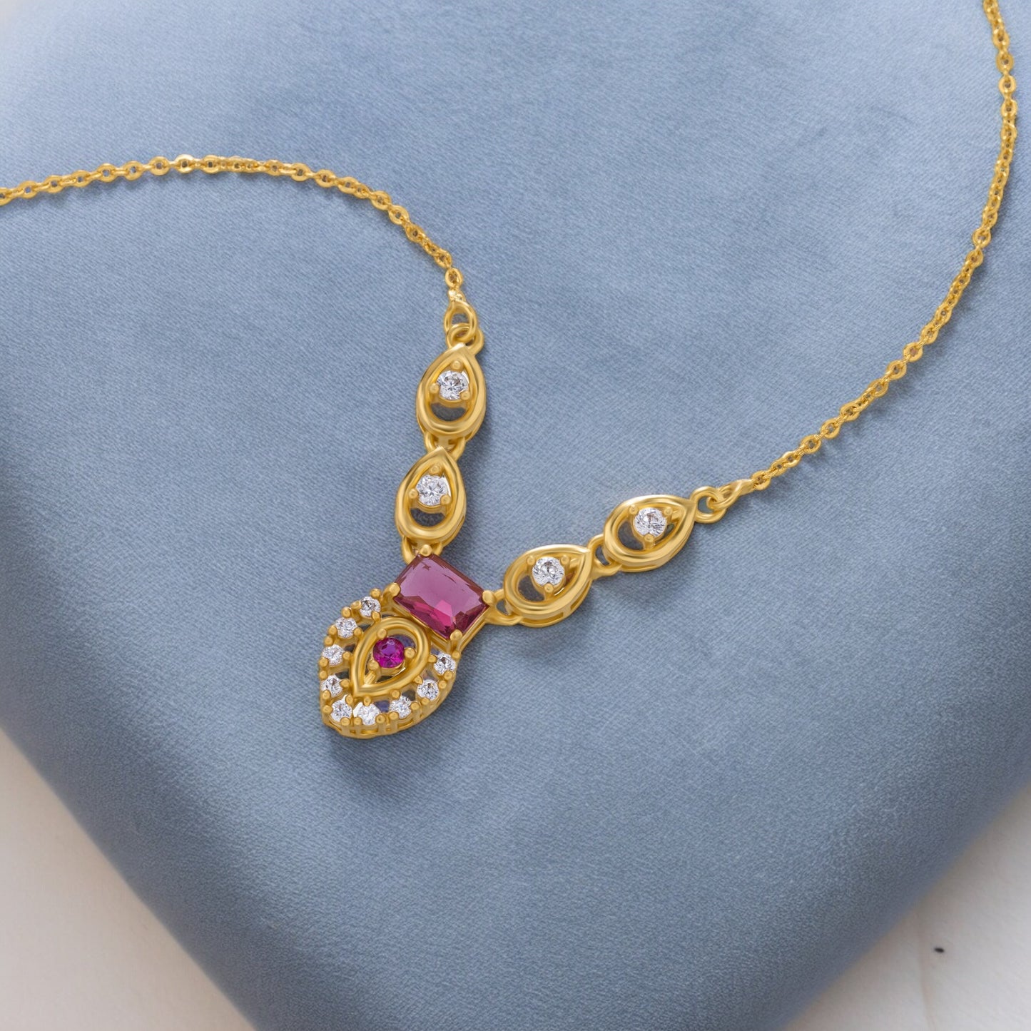 golden necklace with a ruby stone and diamonds