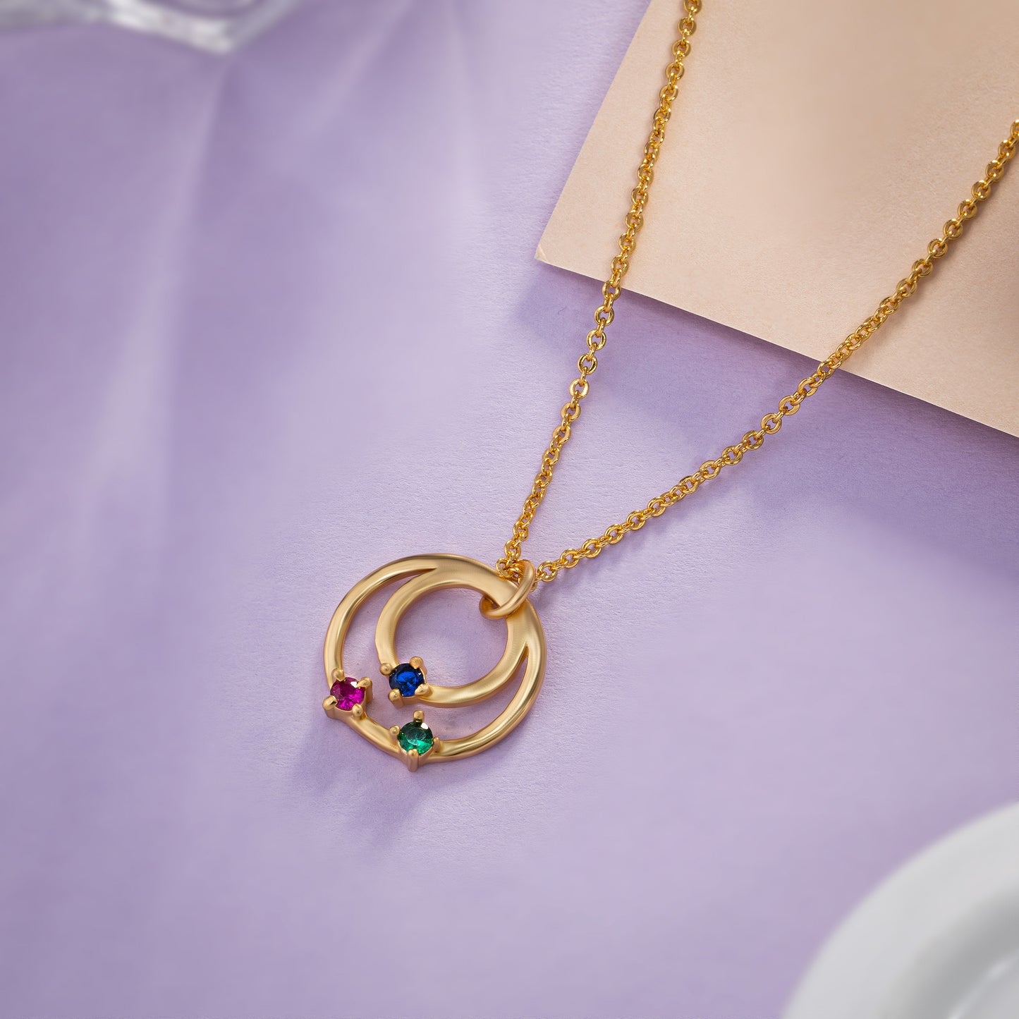 golden necklace with circle pendant and rainbow stones