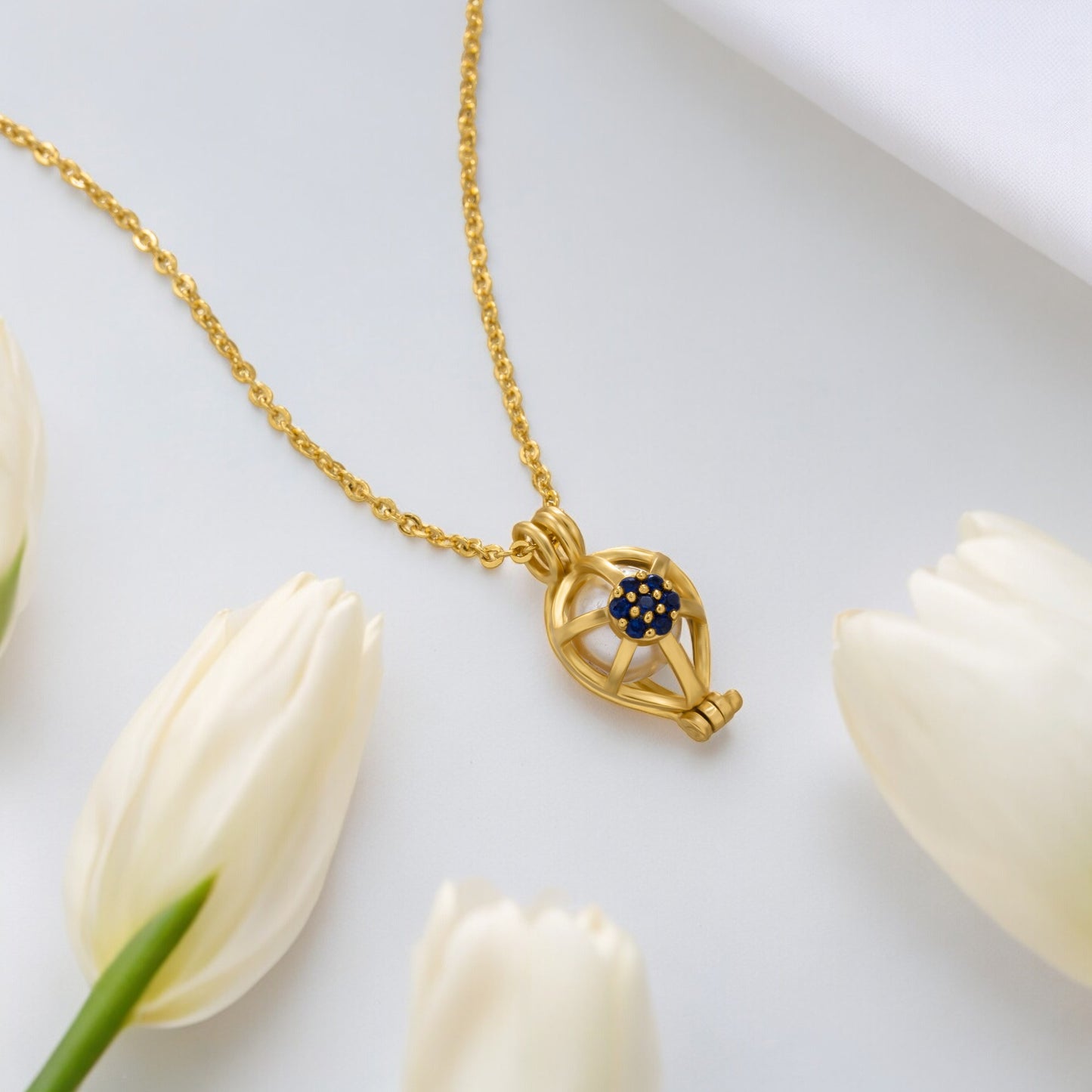 golden necklace with a blue sapphire stone