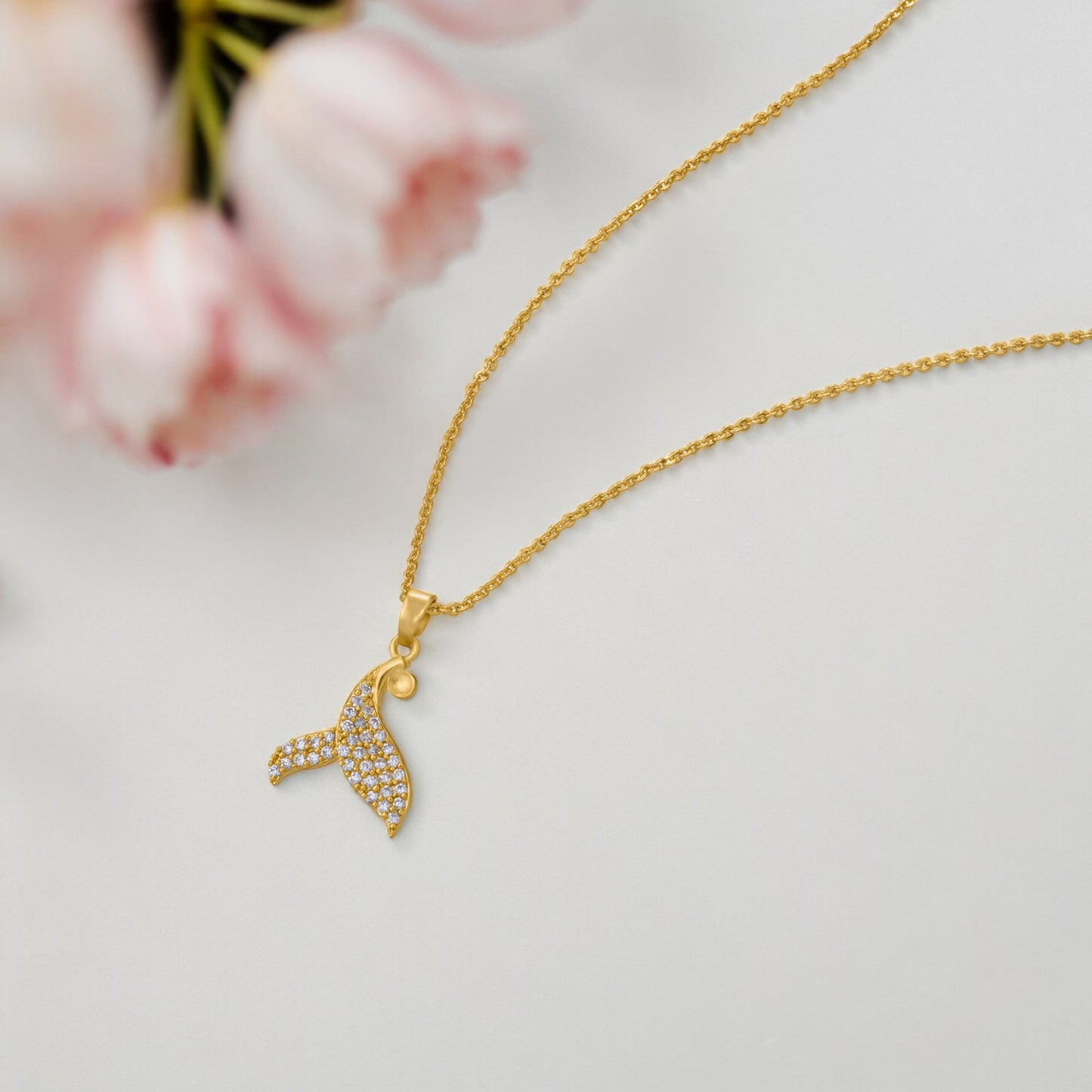 golden necklace with a diamond dolphin pendant