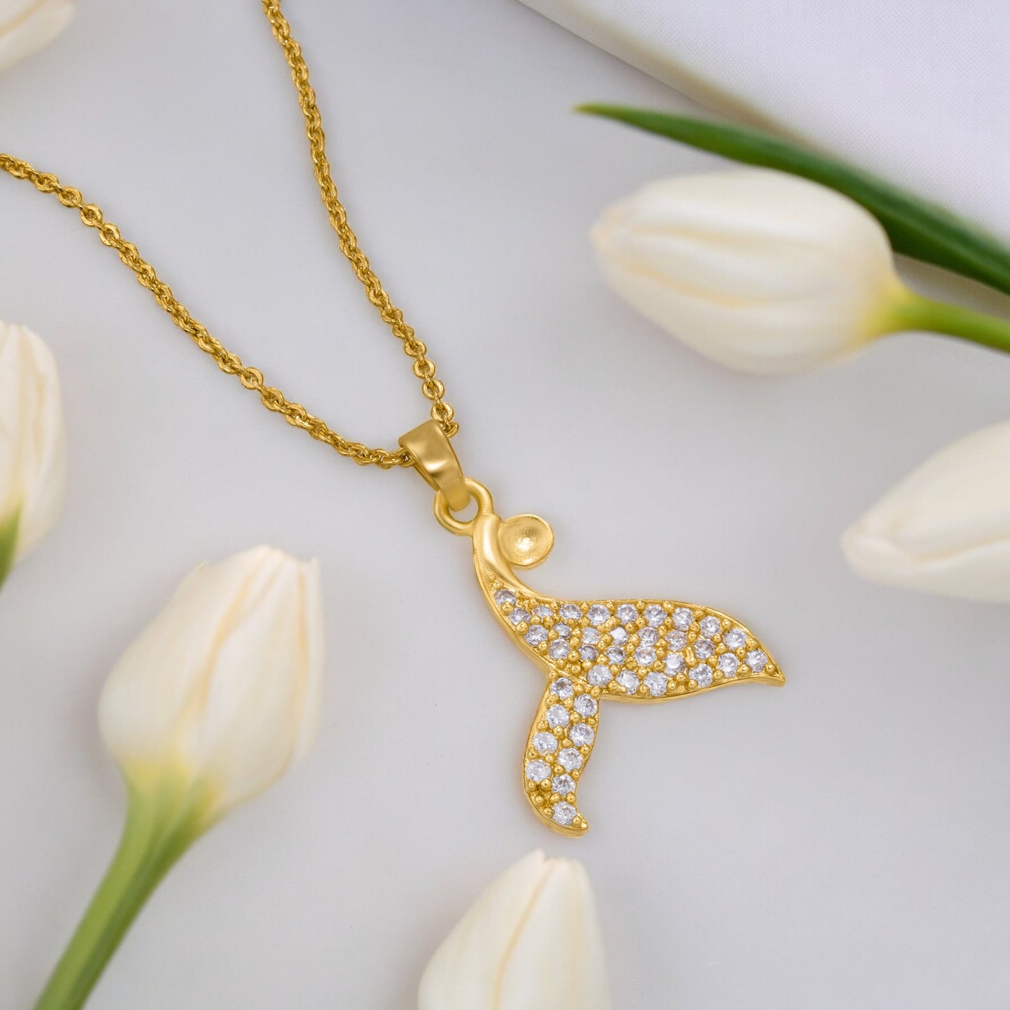 golden necklace with a diamond dolphin pendant