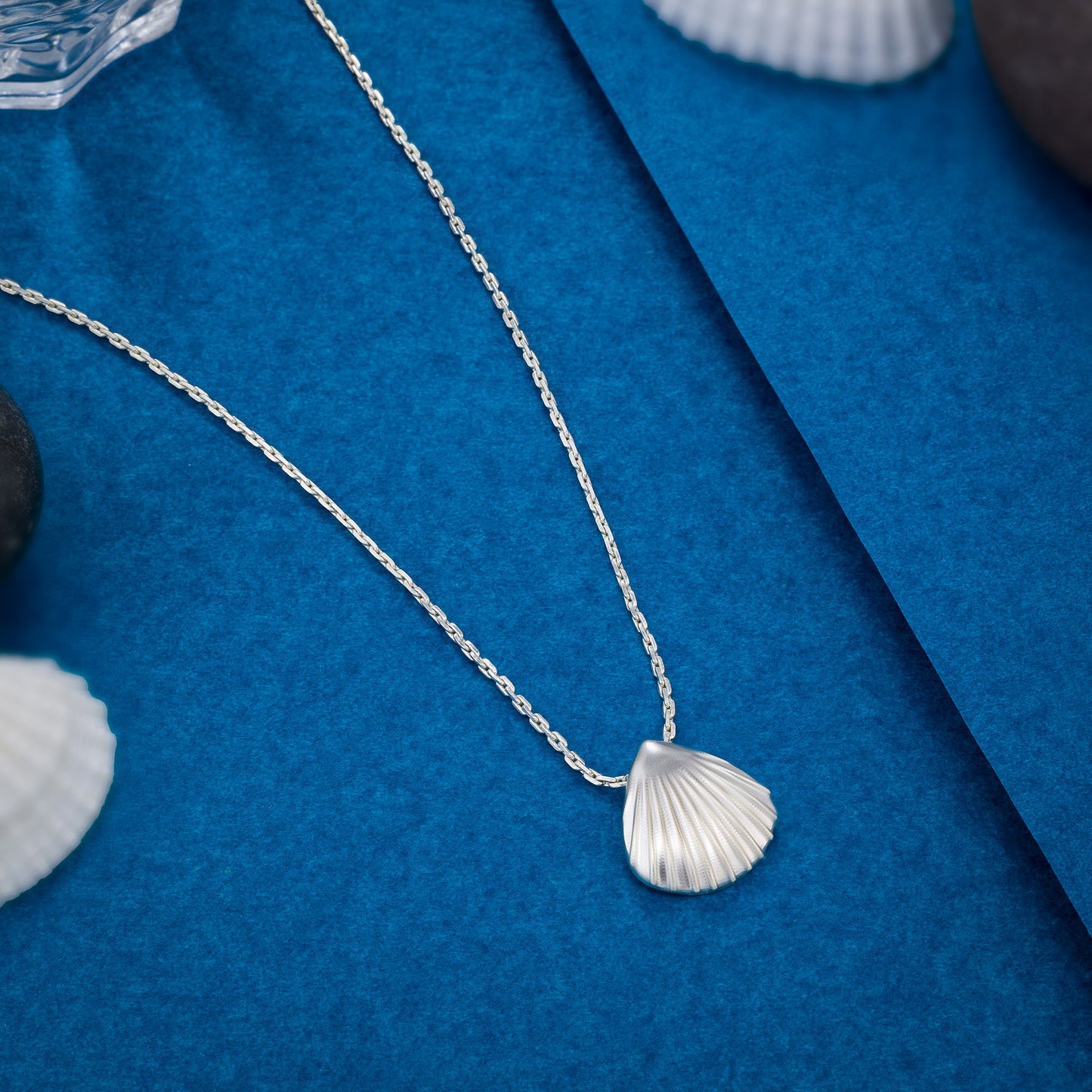 silver necklace with a shell on it