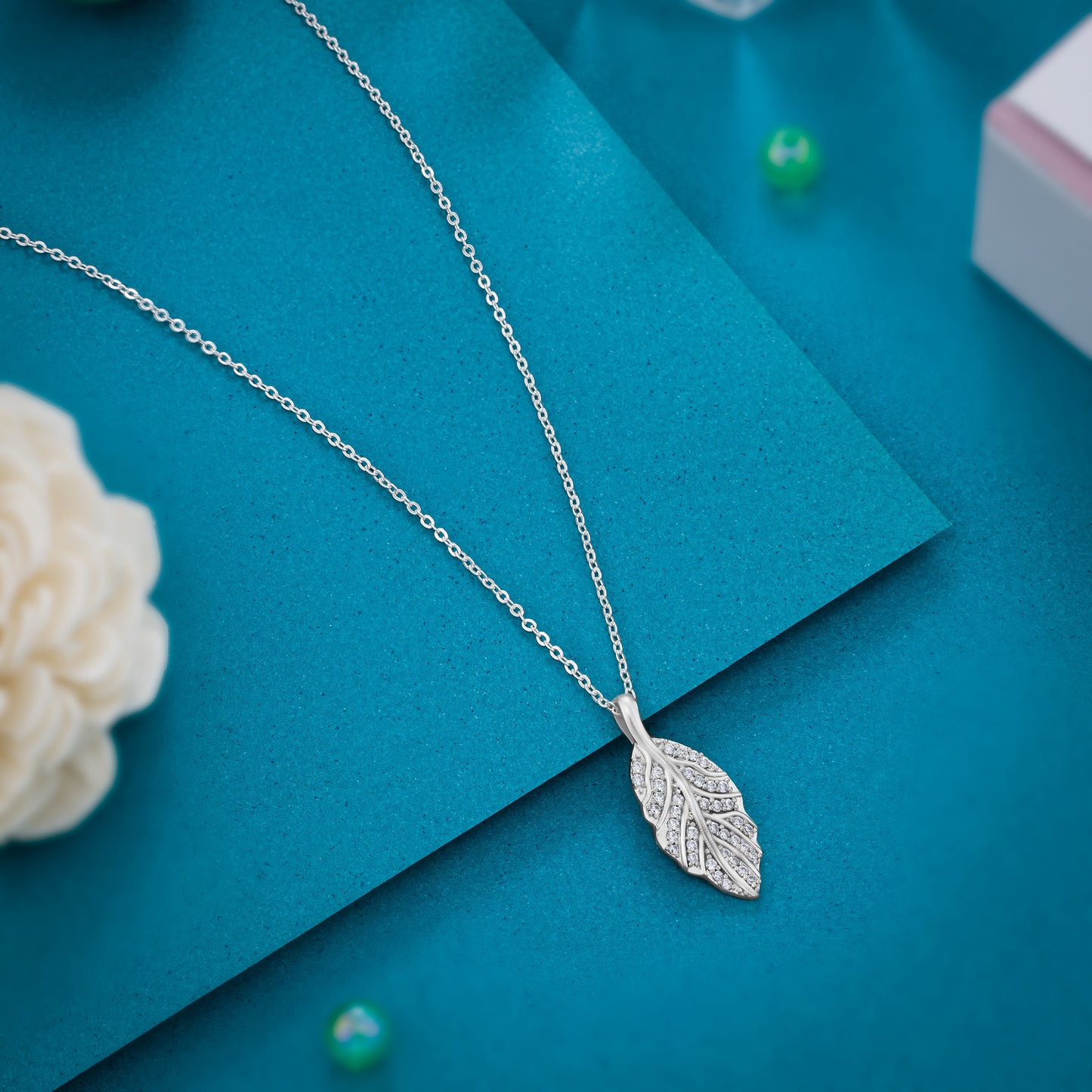 silver necklace with a diamond leaf pendant