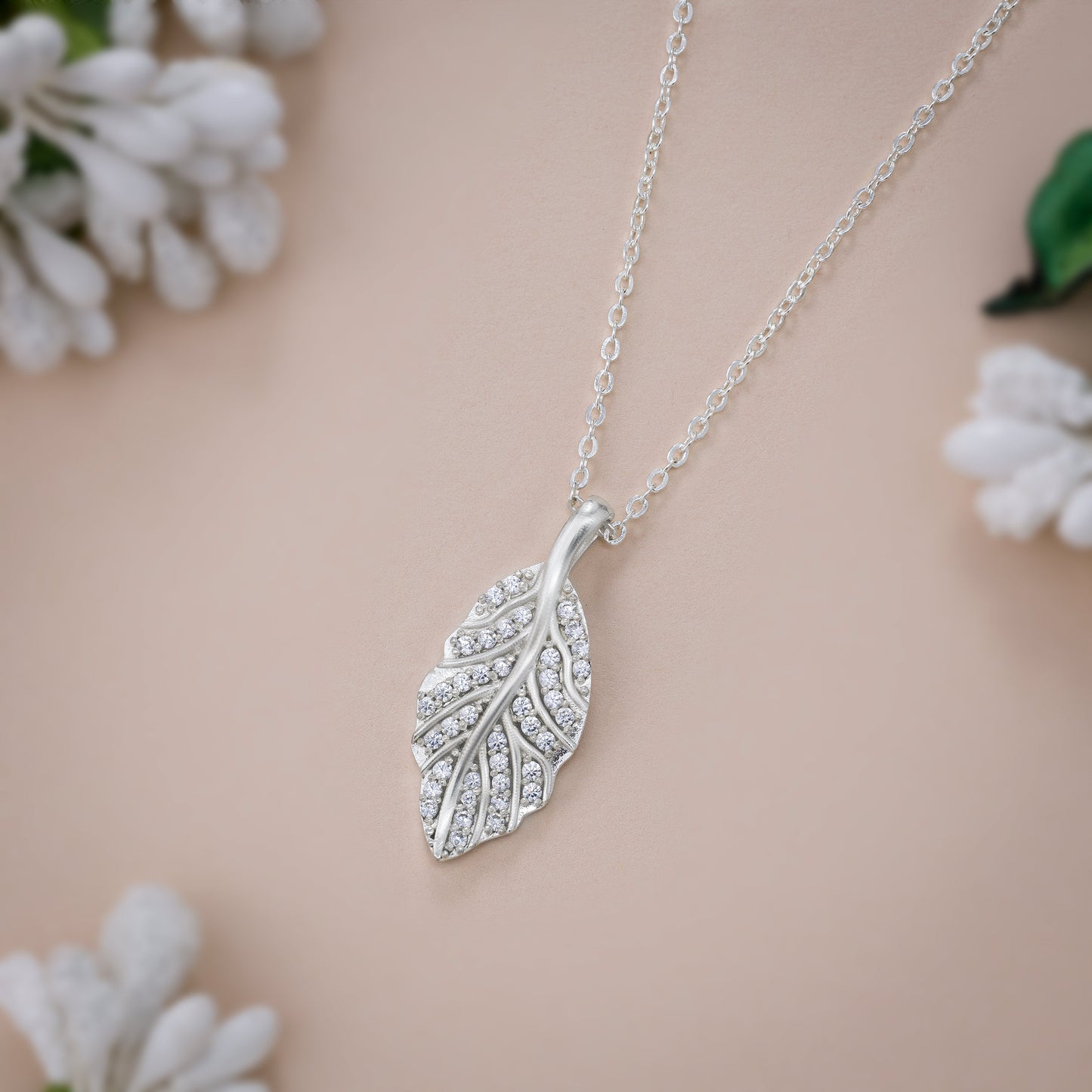 silver necklace with a diamond leaf pendant