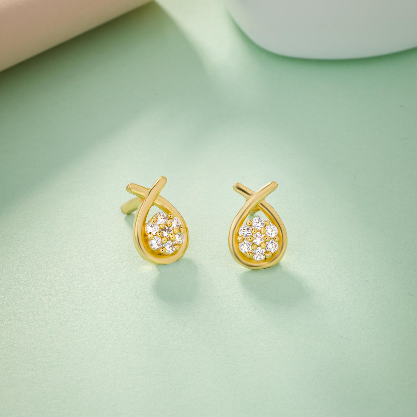 pair of golden earrings with white stones