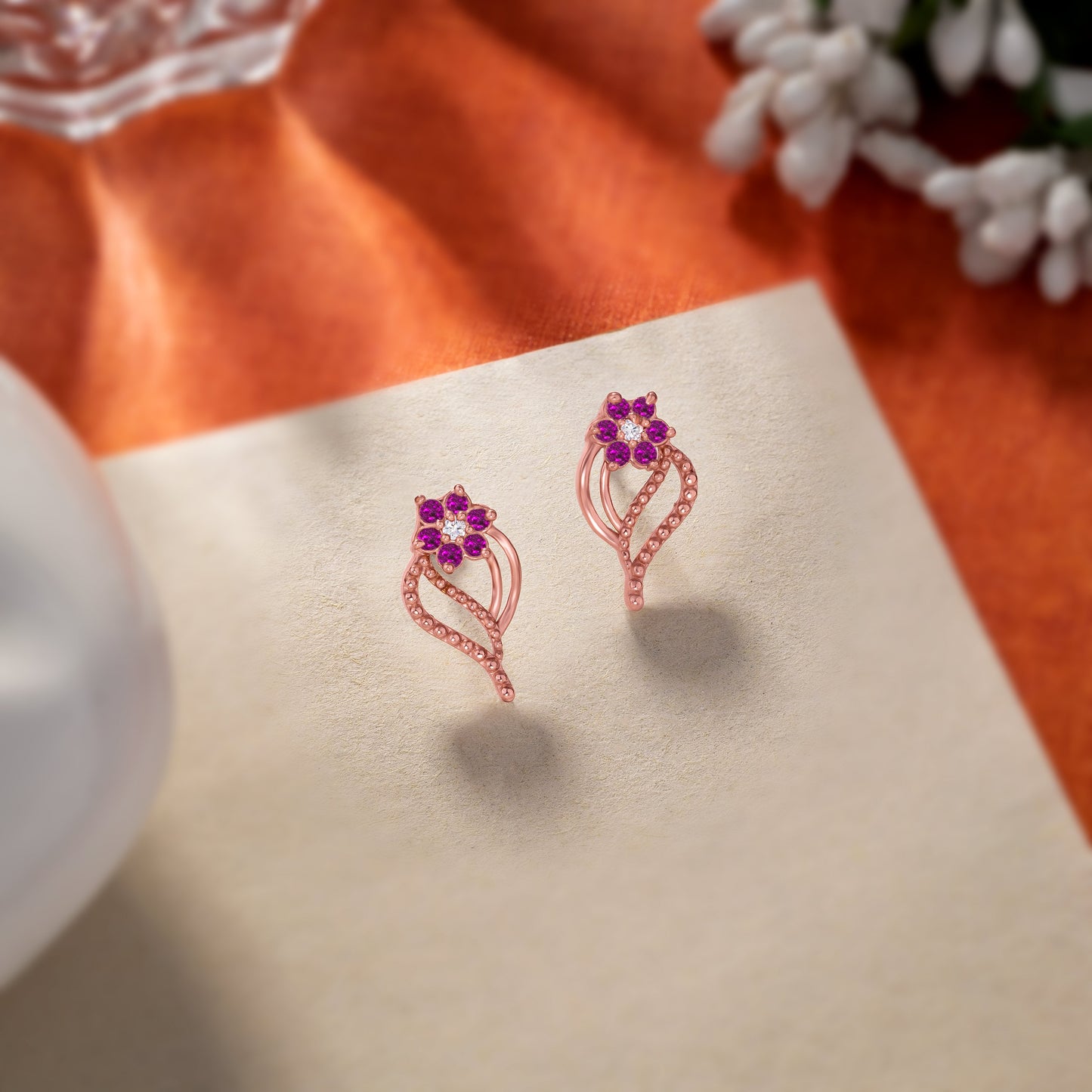 pair of rose gold earrings with diamonds and stones