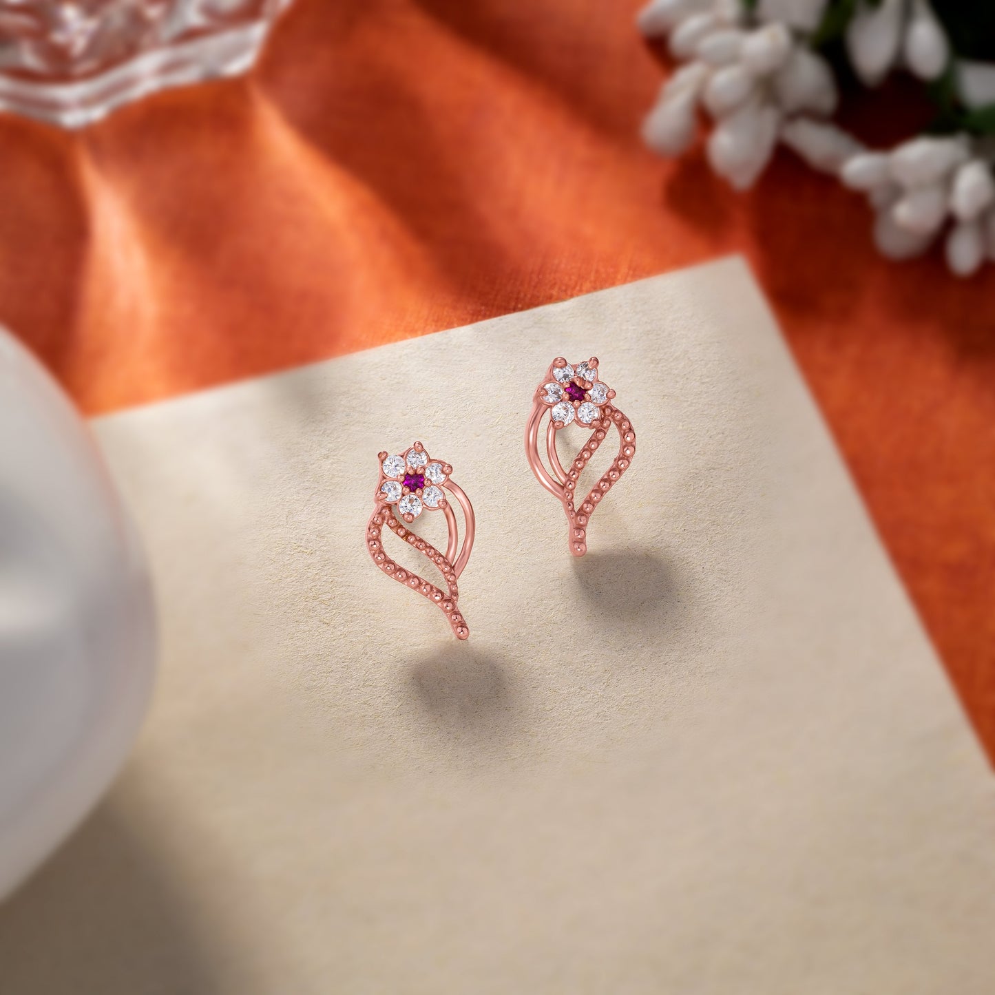 pair of rose gold earrings with diamonds and stones