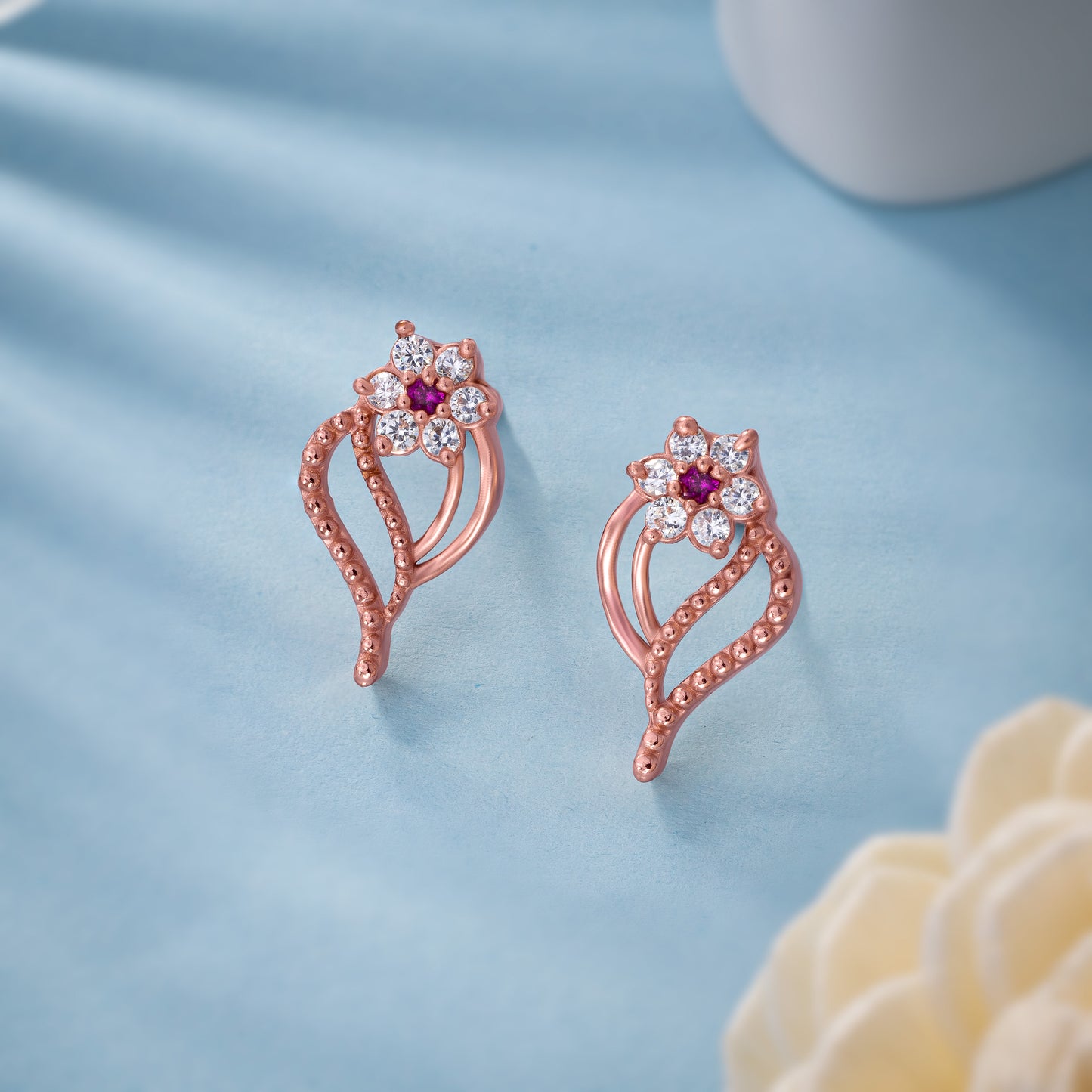 pair of rose gold earrings with diamonds and stones