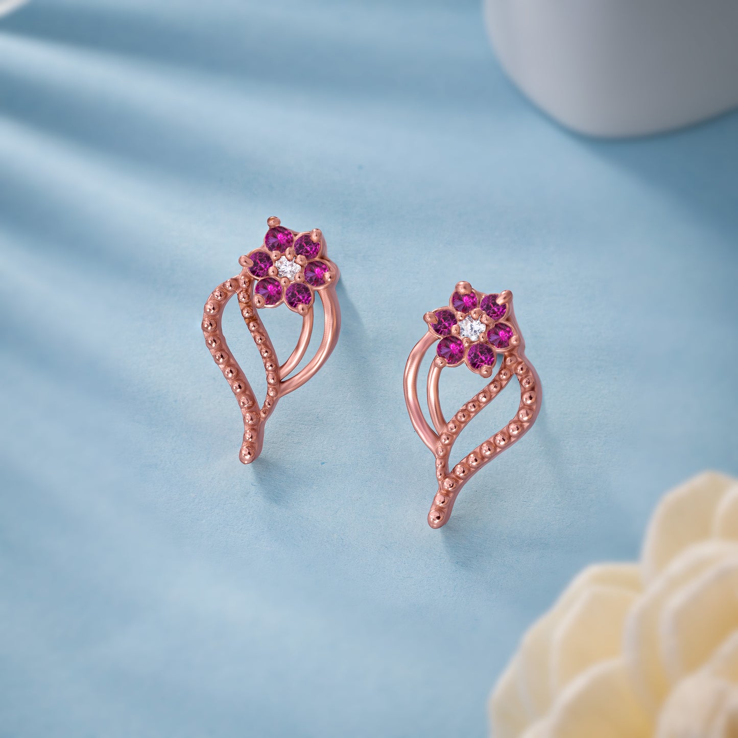 pair of rose gold earrings with diamonds and stones