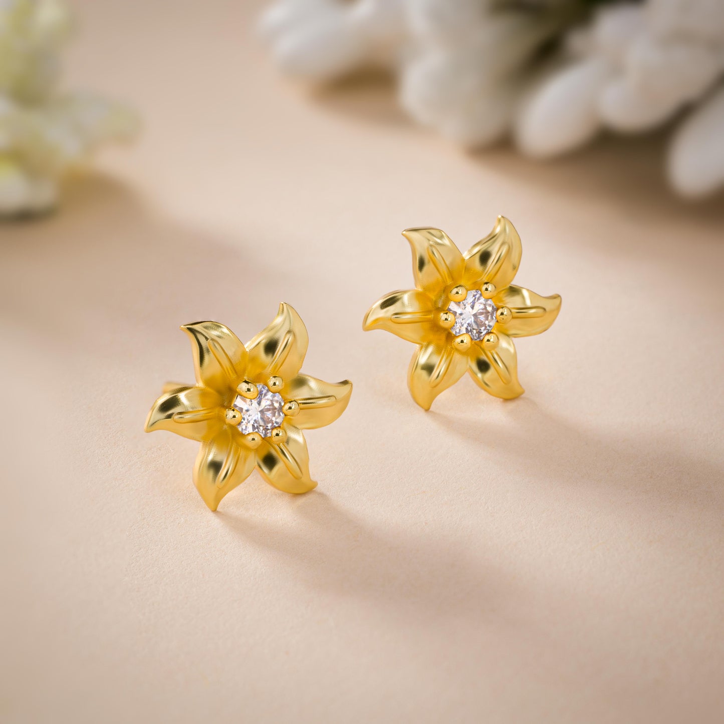 pair of golden earrings with white stones