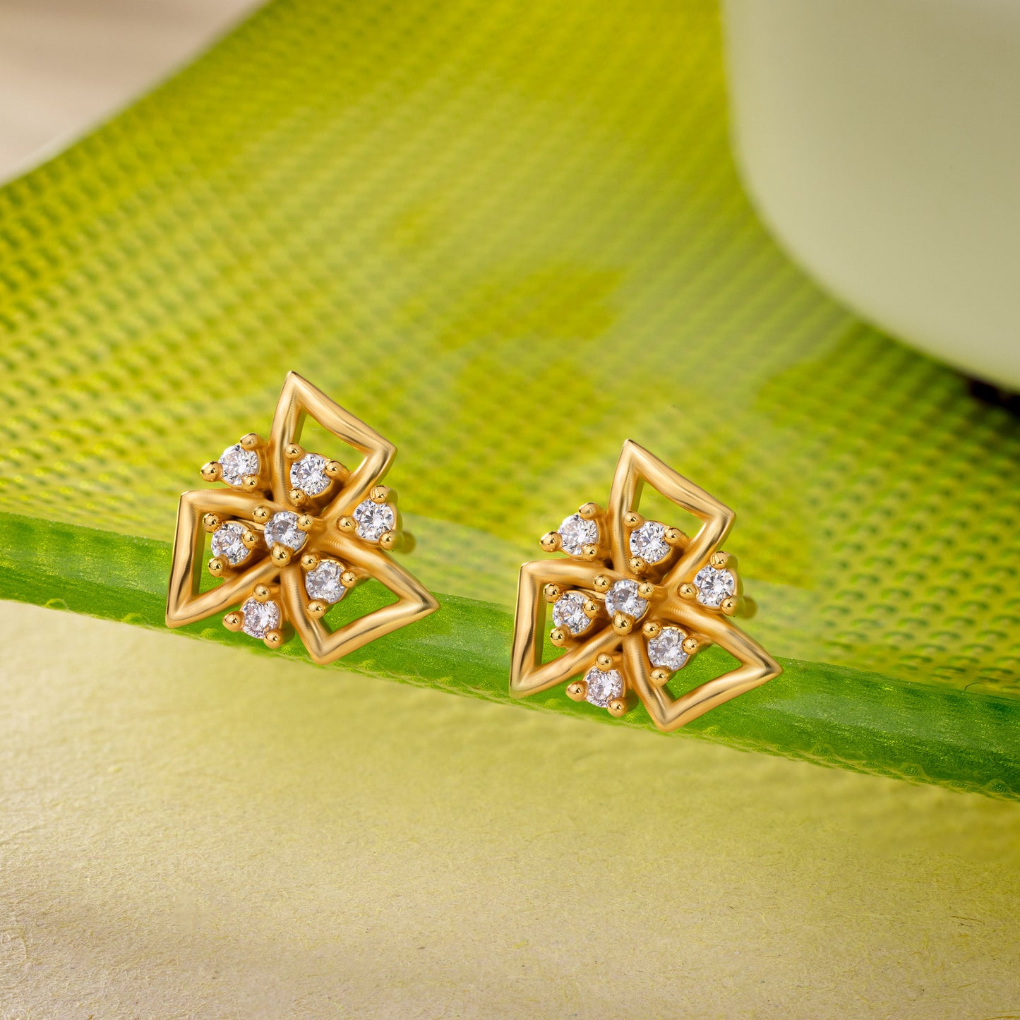 pair of golden earrings with white stones