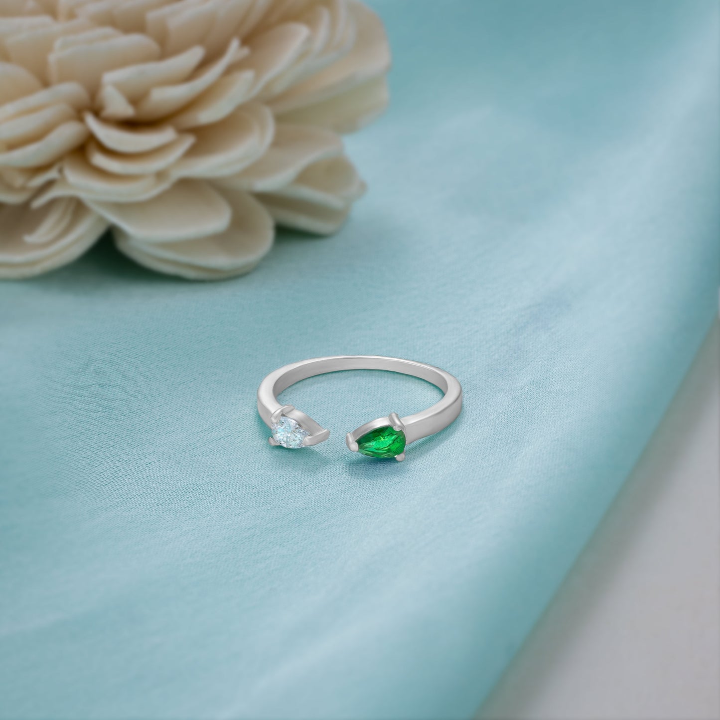 silver ring with a green stone and a diamond