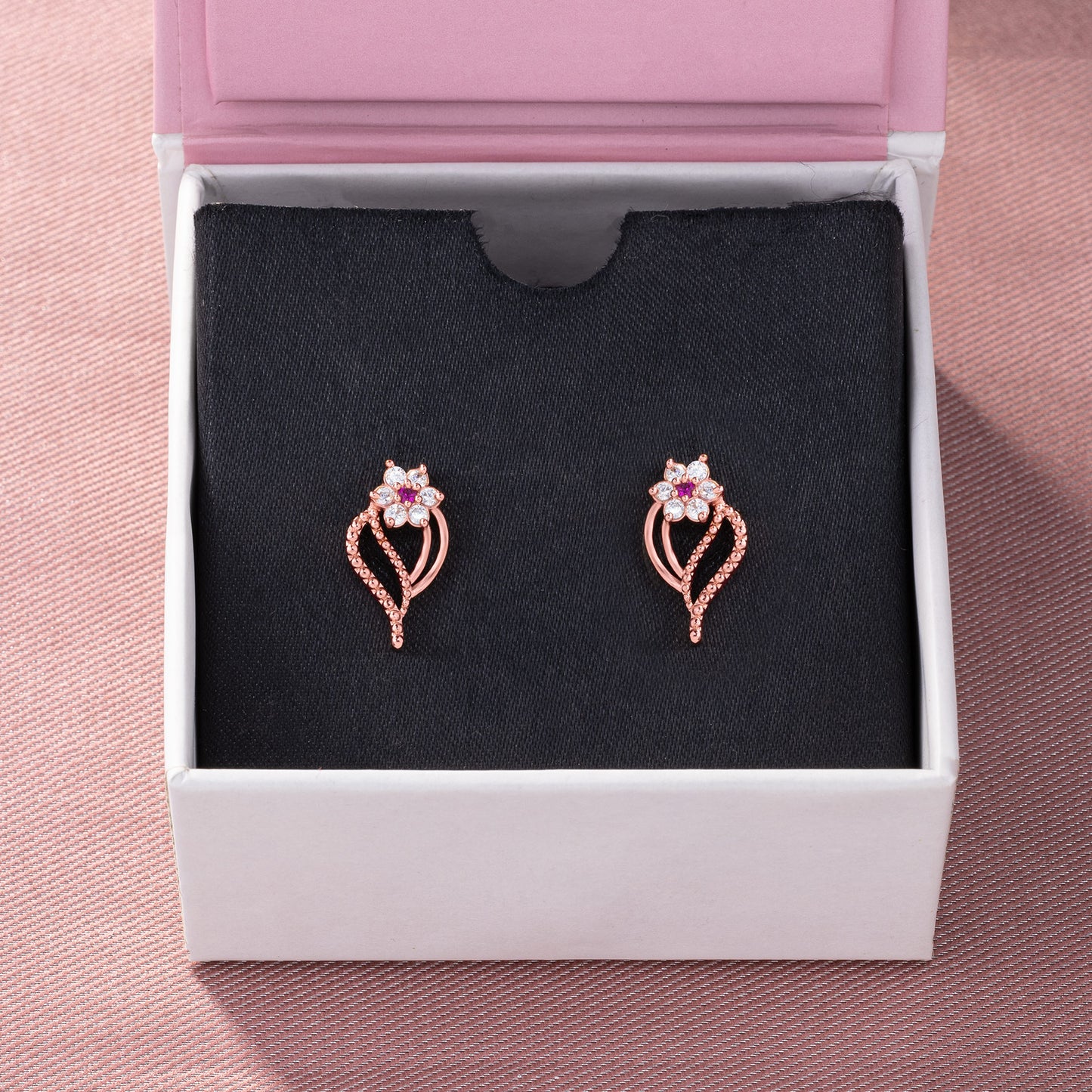 pair of rose gold earrings with diamonds and stones