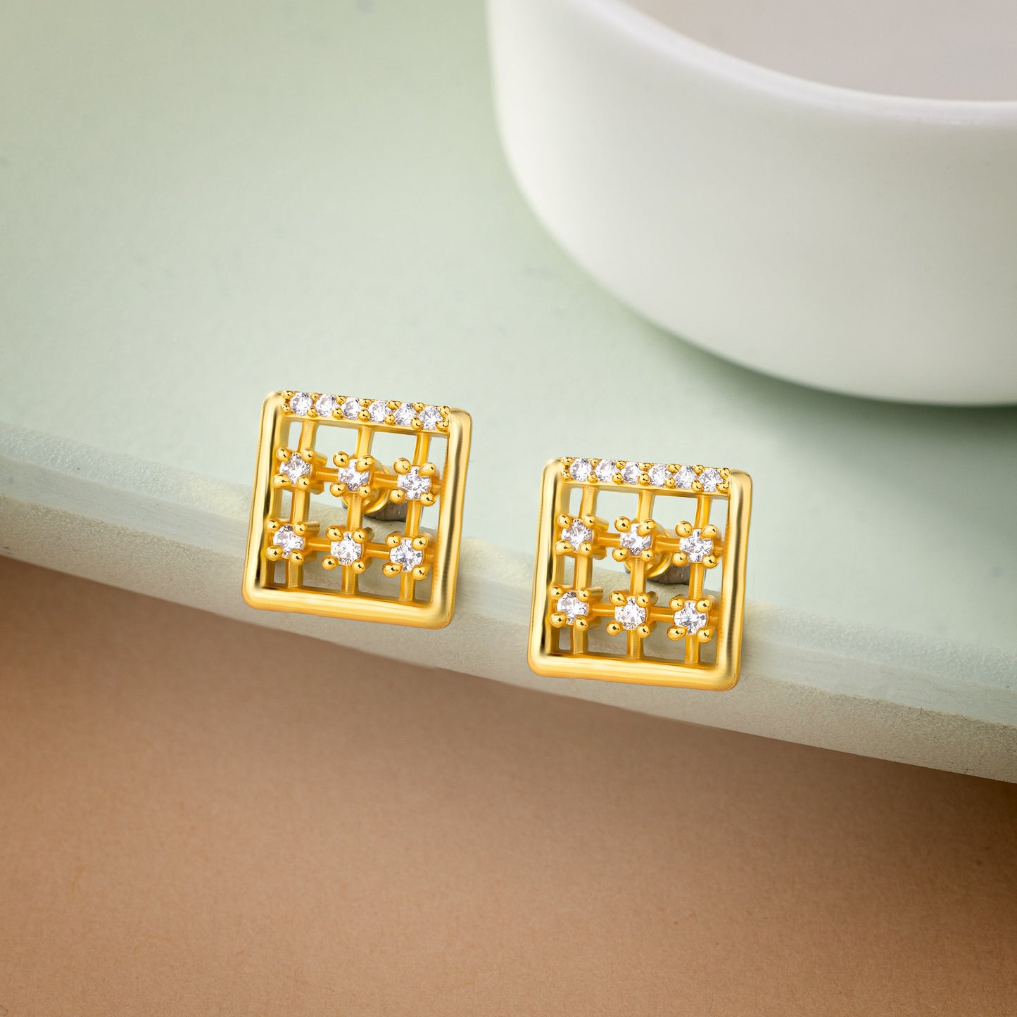 pair of golden earrings with white diamonds