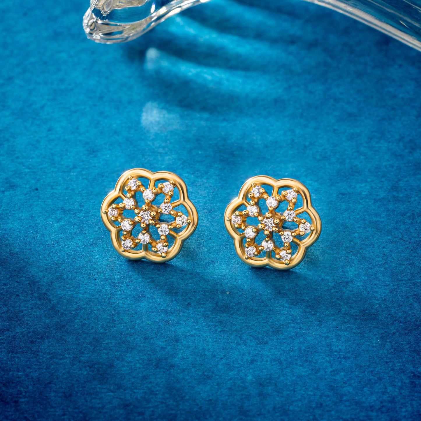 pair of golden earrings with white diamonds