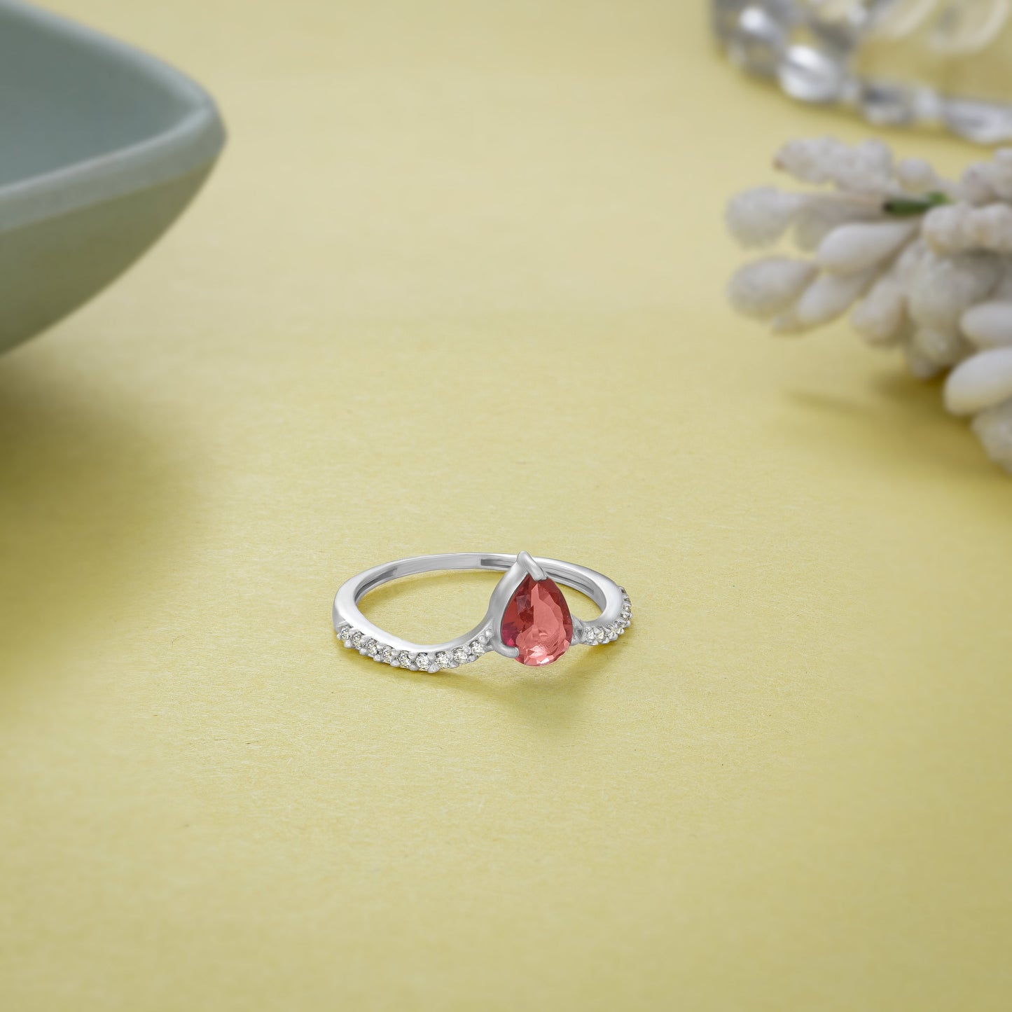 silver ring with a red sapphire and diamonds