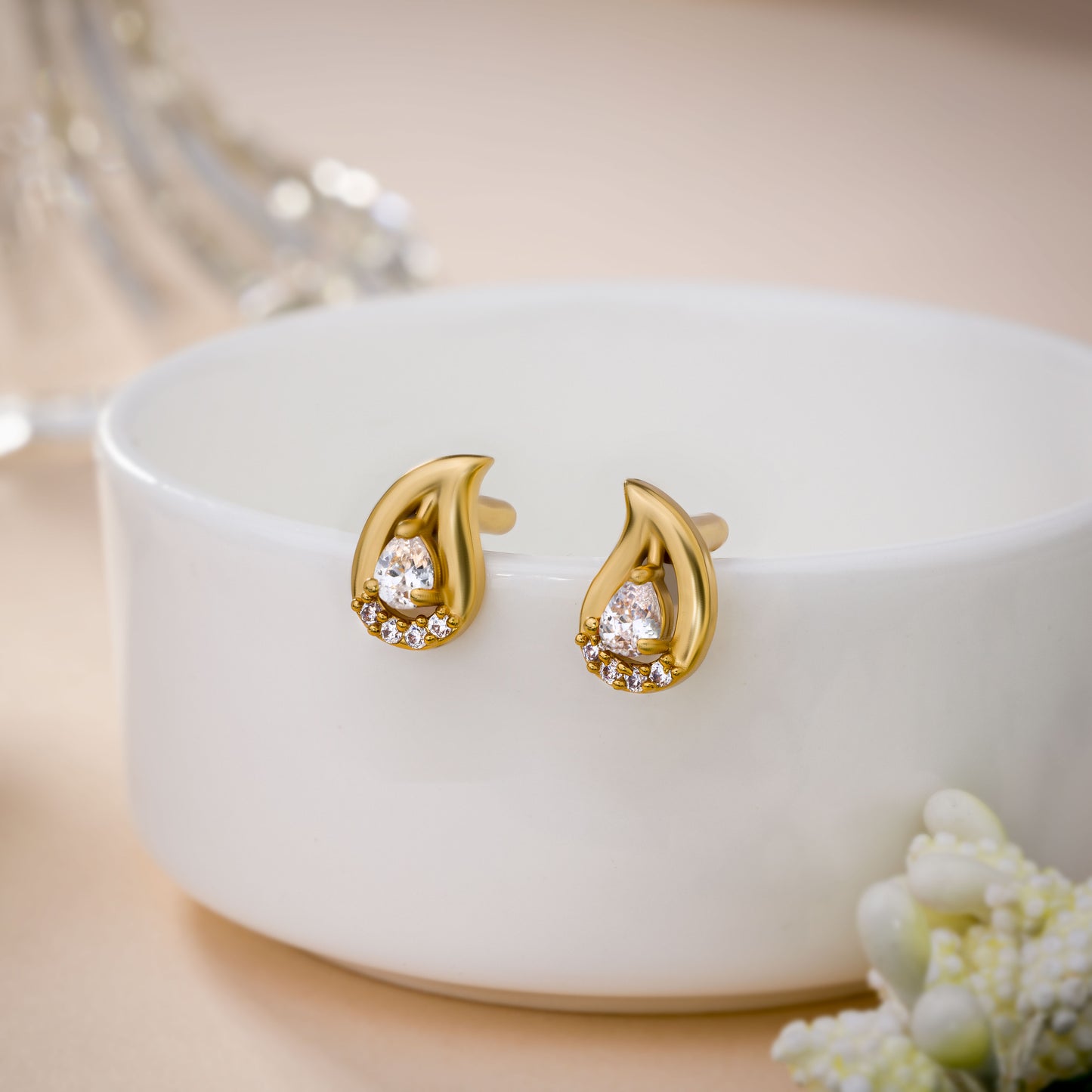 pair of golden earrings with white stones