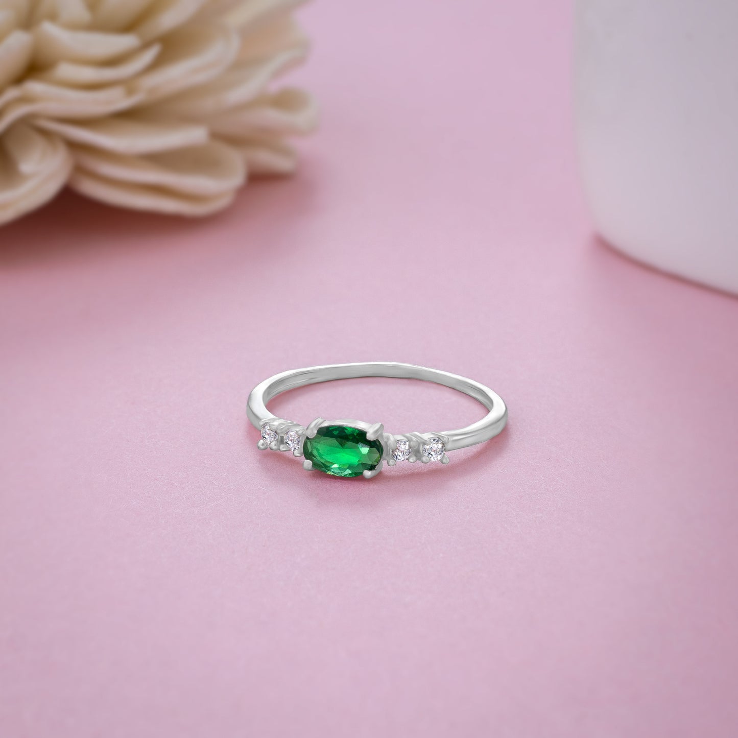 silver ring with a sapphire and green diamonds