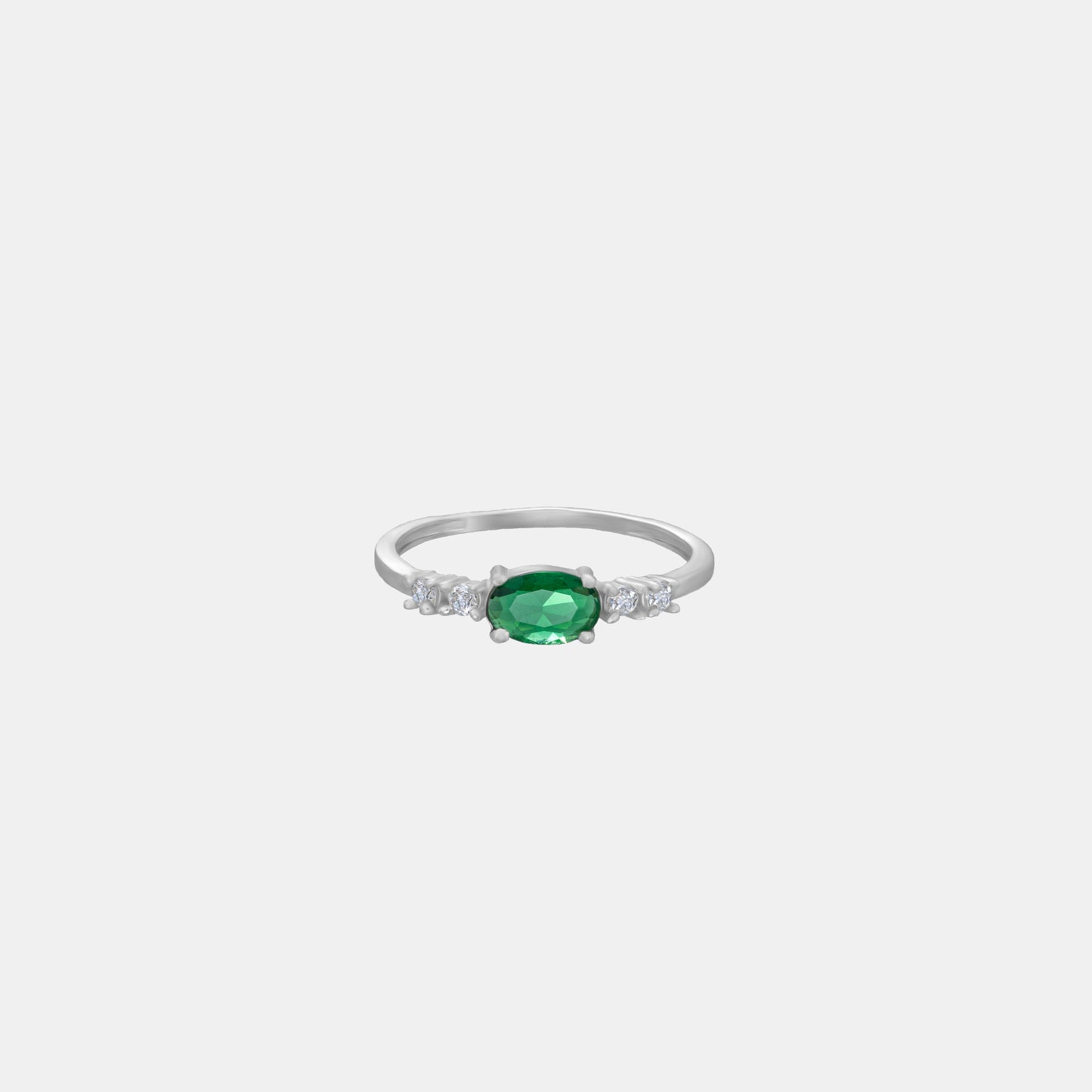 silver ring with a sapphire and green diamonds