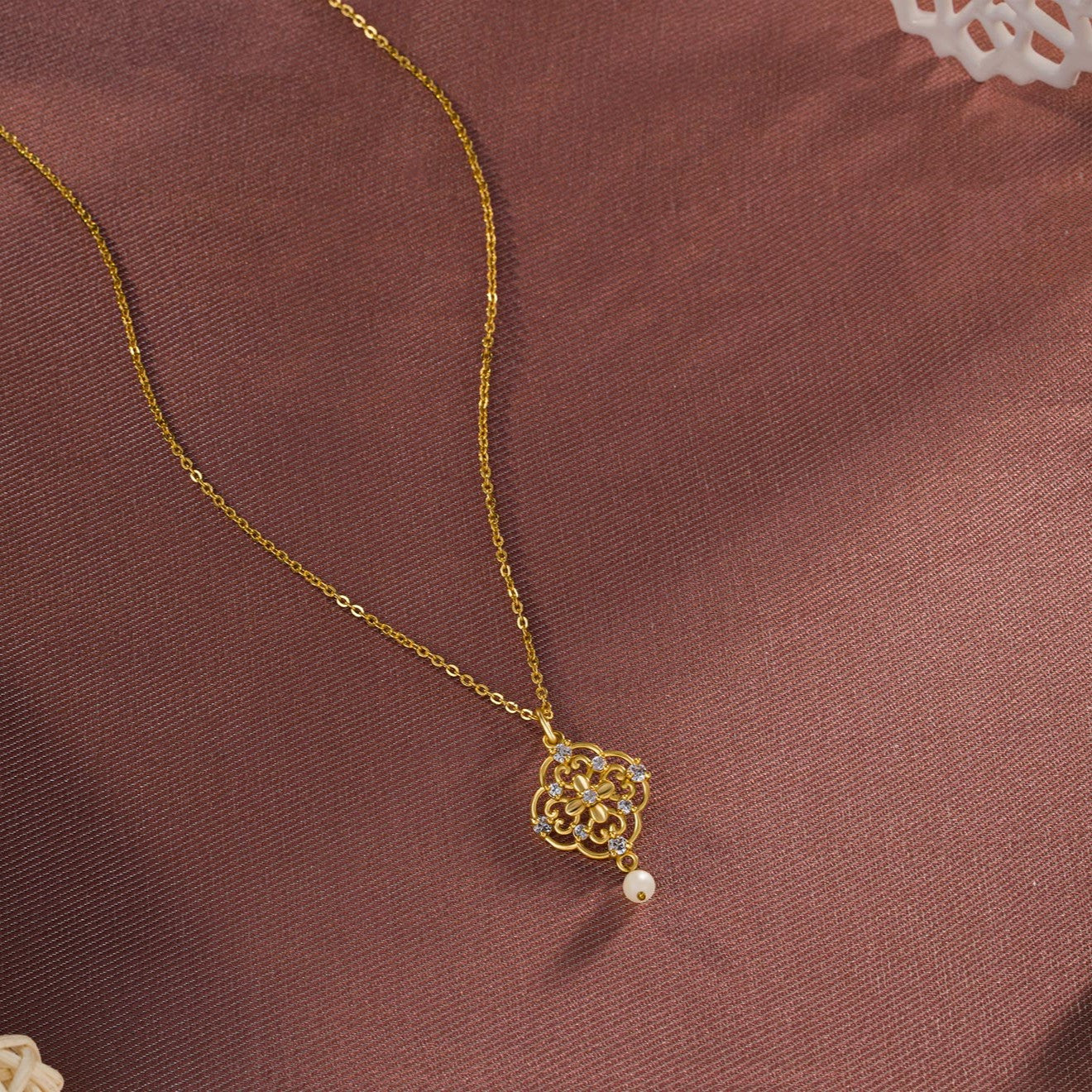 golden necklace with a flower design on it