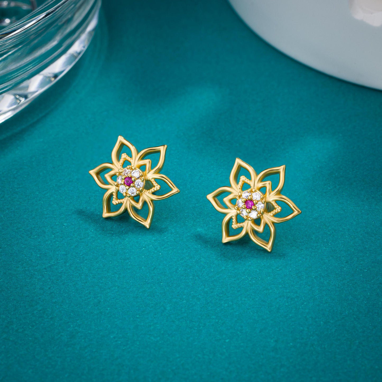 pair of golden earrings with a flower design