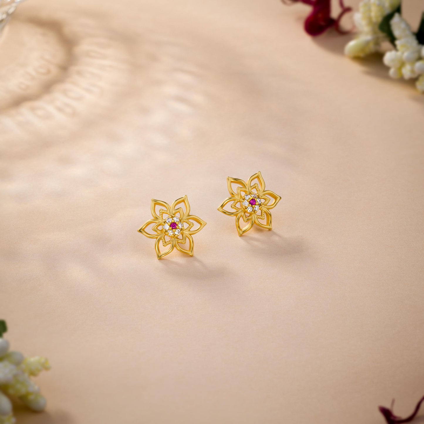 pair of golden earrings with a flower design