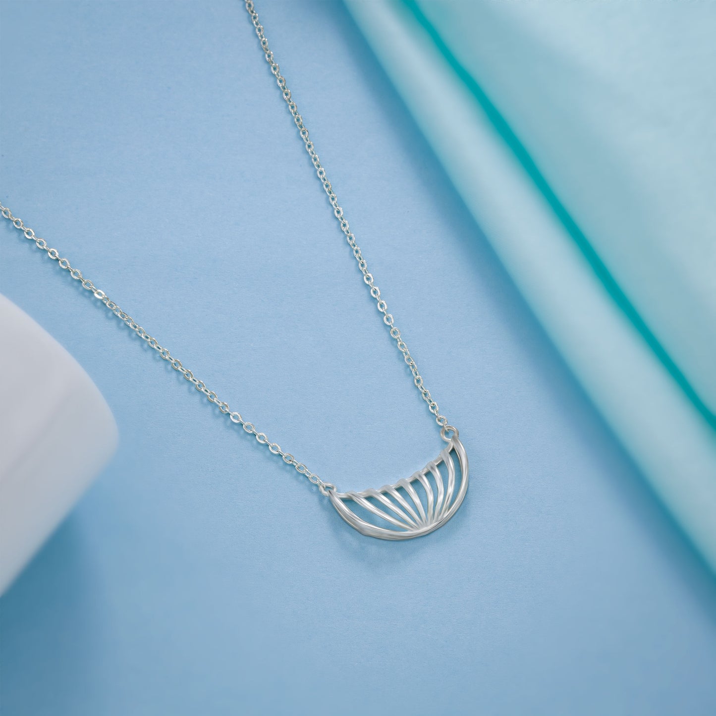 silver necklace with a large curved design