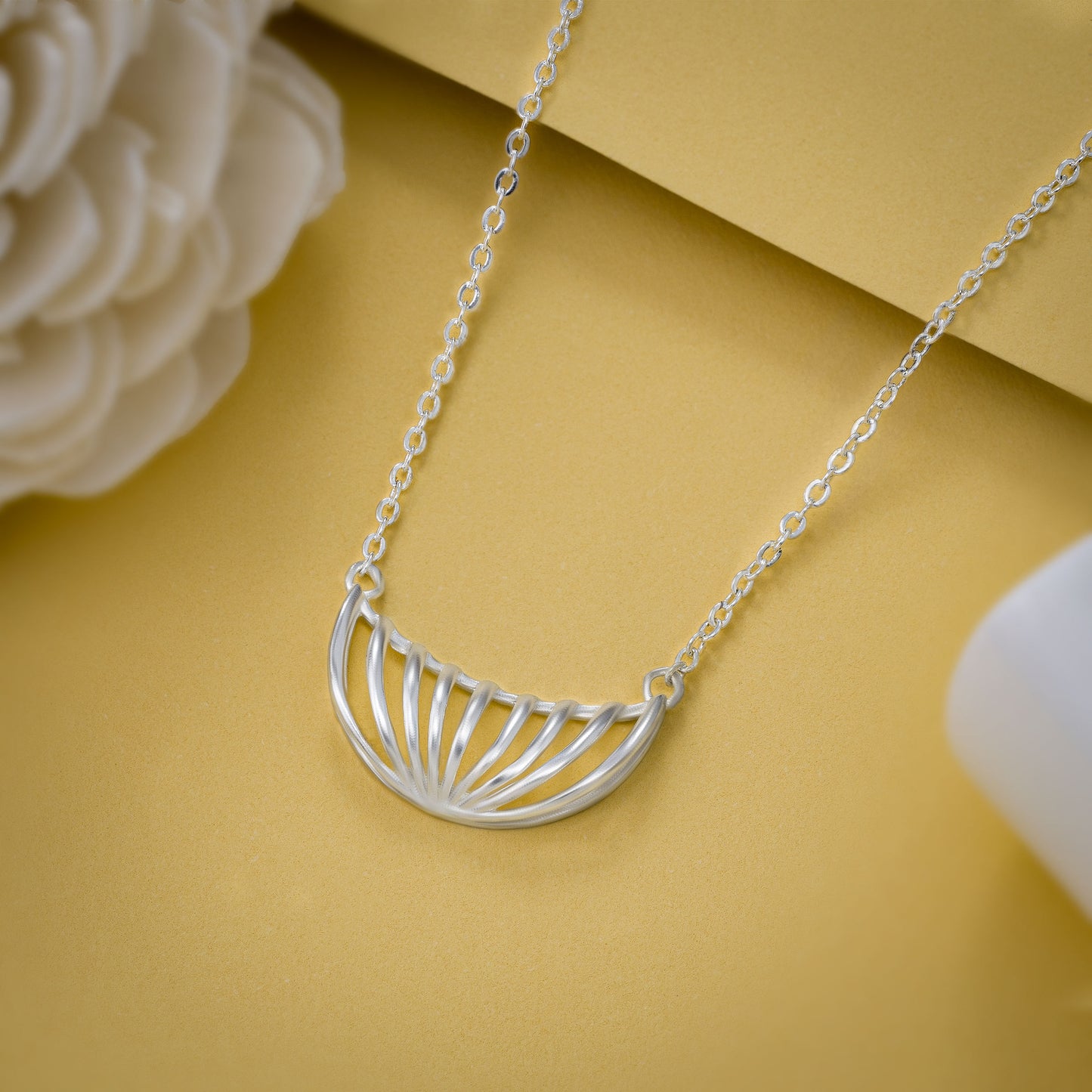 silver necklace with a large curved design