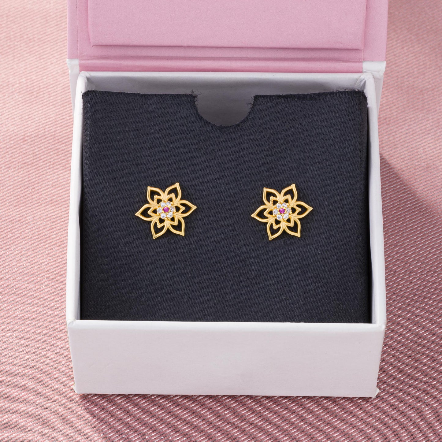 pair of golden earrings with a flower design