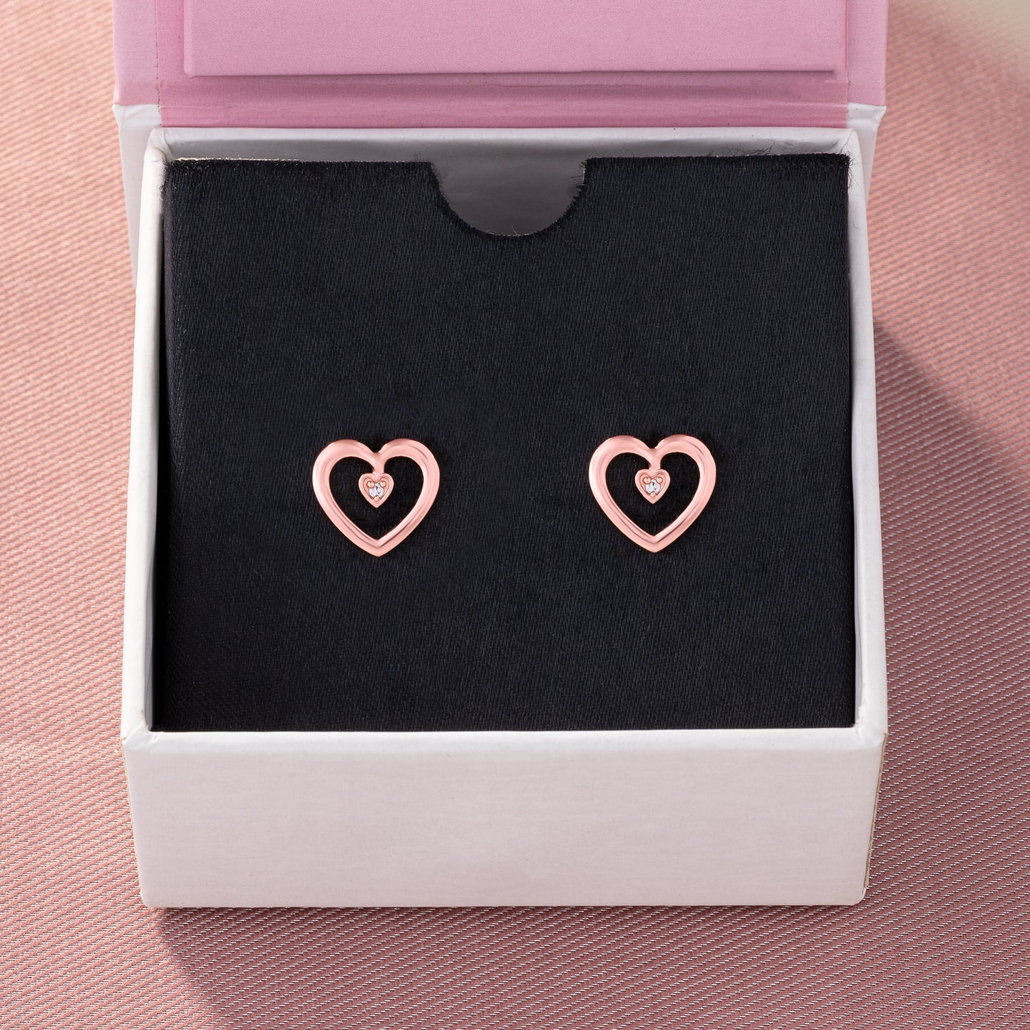 pair of rose gold heart earrings with diamond