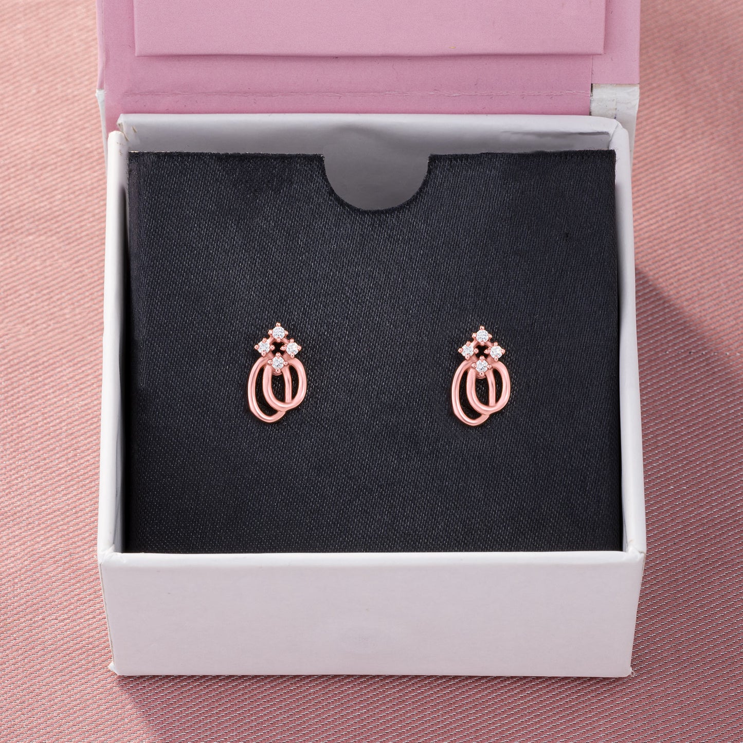 pair of rose gold earrings with a diamond