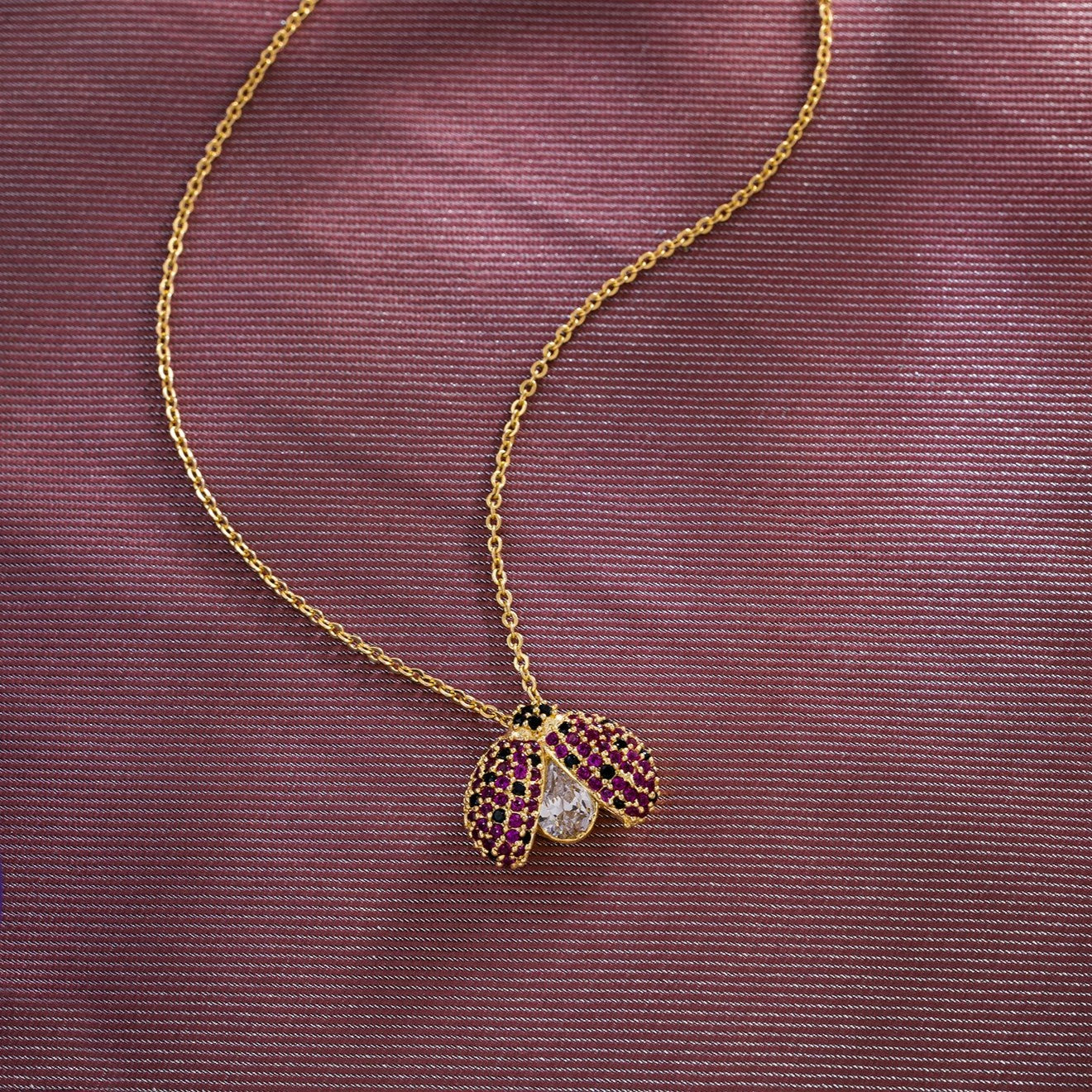 golden necklace with lady bug pendant