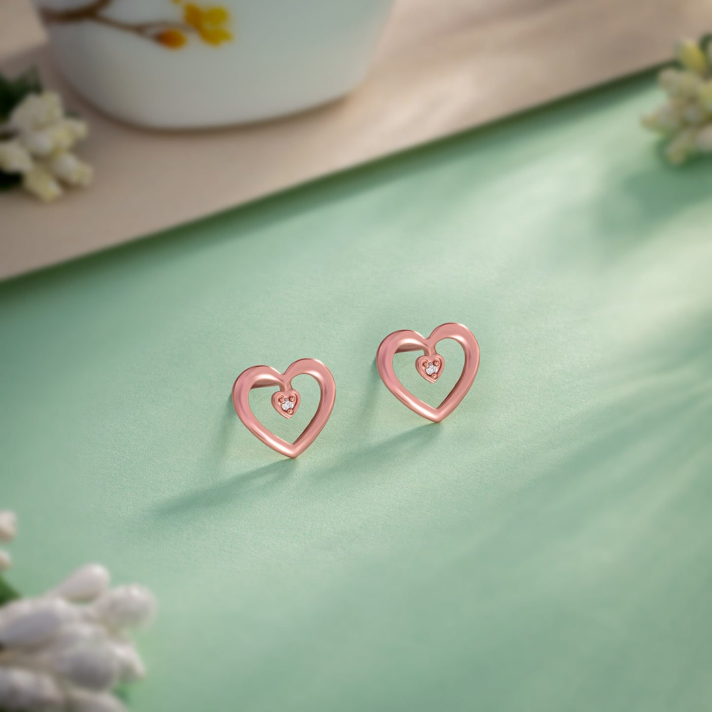 pair of rose gold heart earrings with diamond