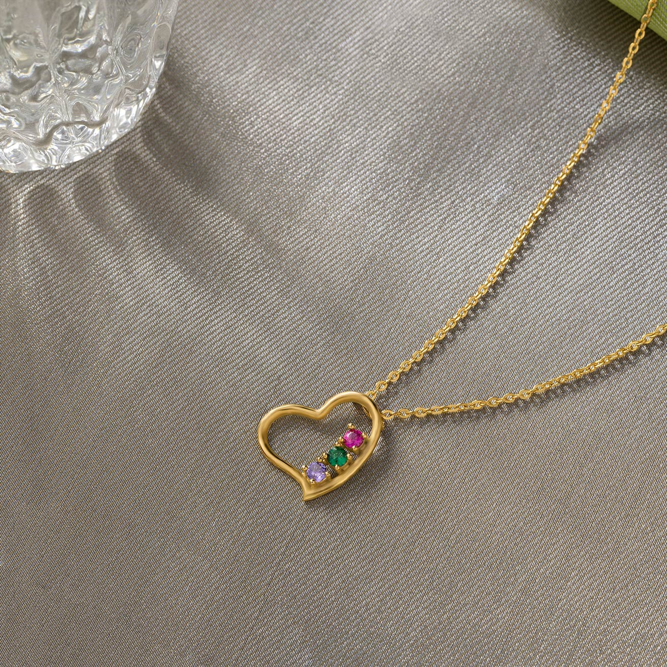 golden necklace with a heart pendant and a rainbow stone