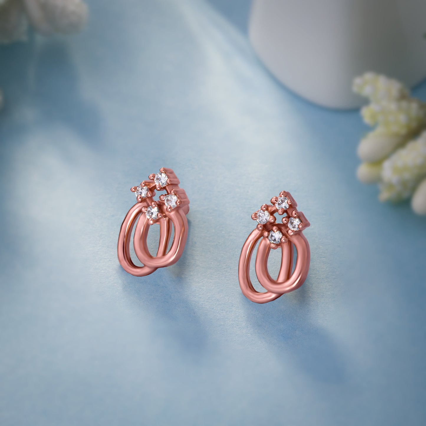 pair of rose gold earrings with a diamond