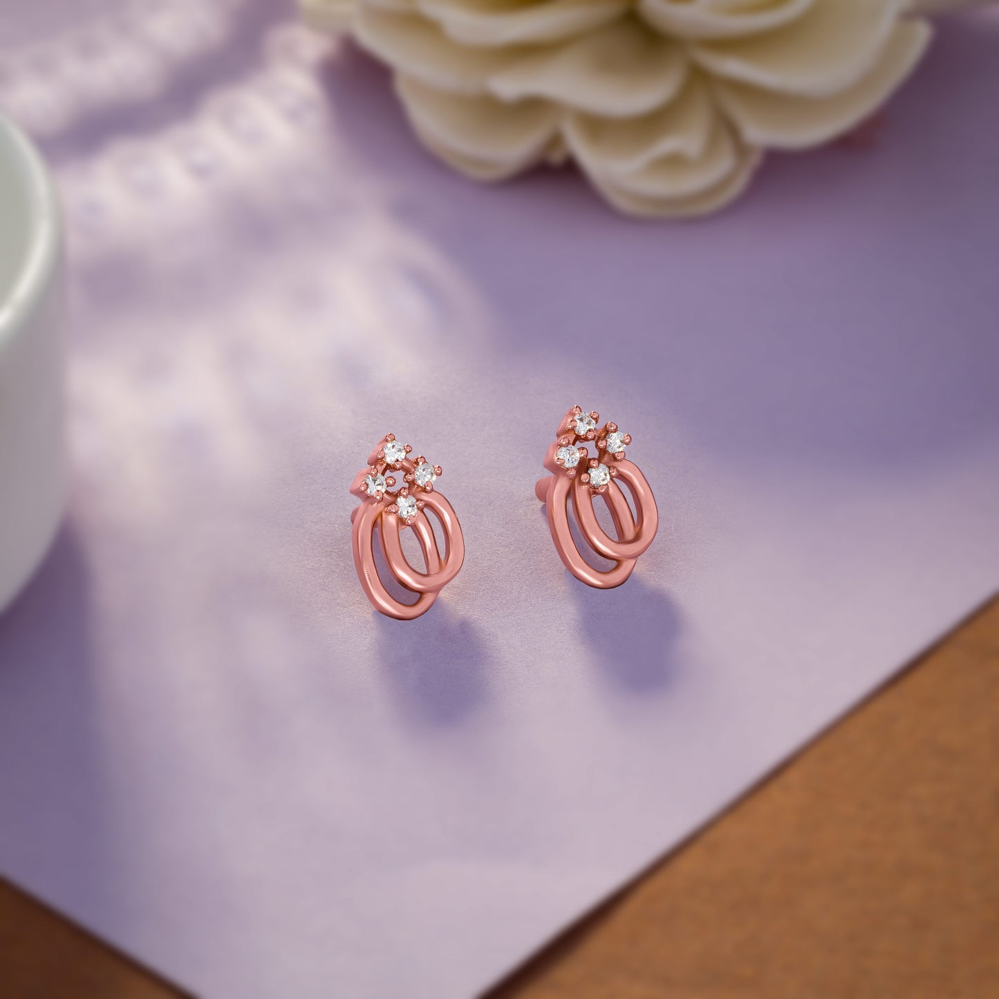 pair of rose gold earrings with a diamond