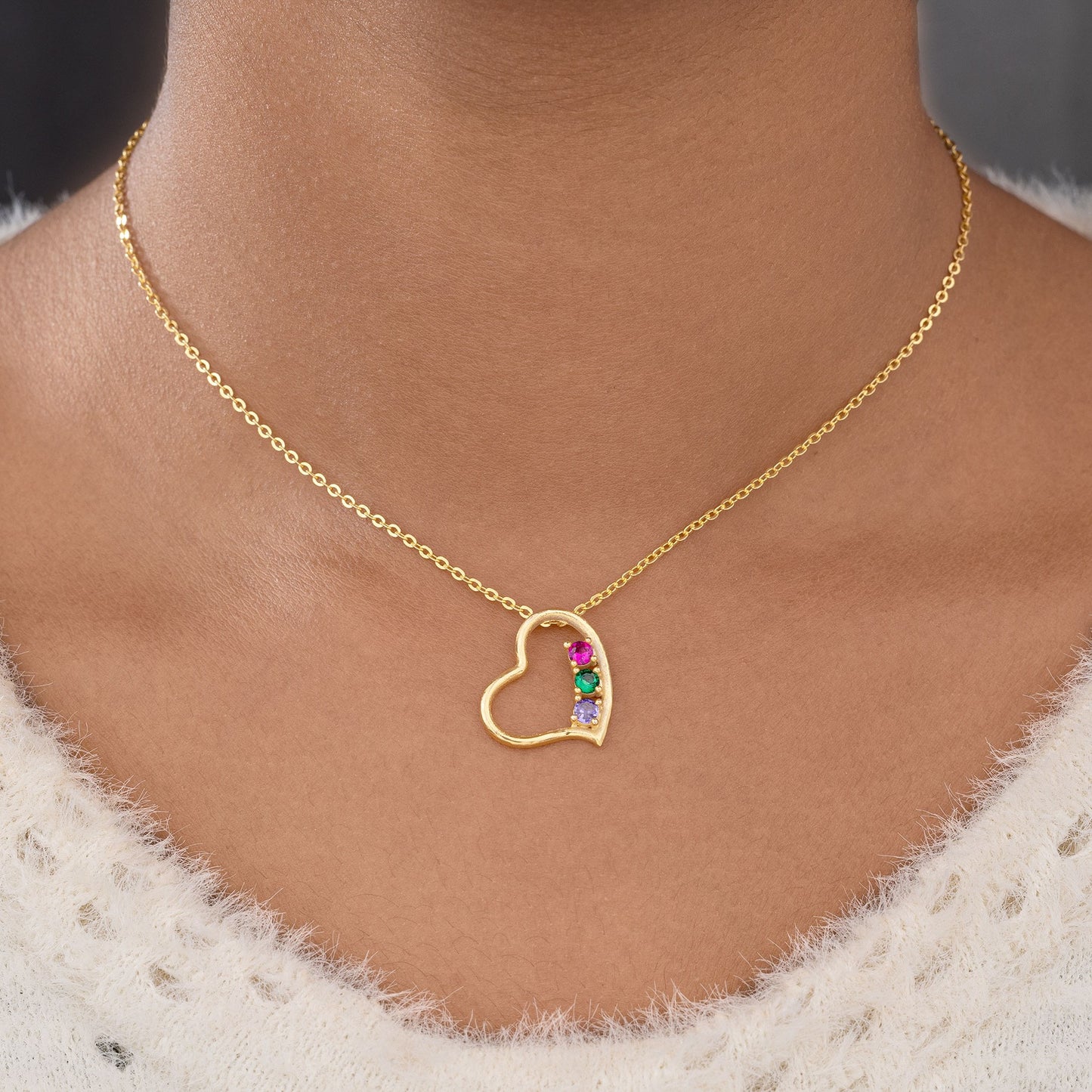 golden necklace with a heart pendant and a rainbow stone