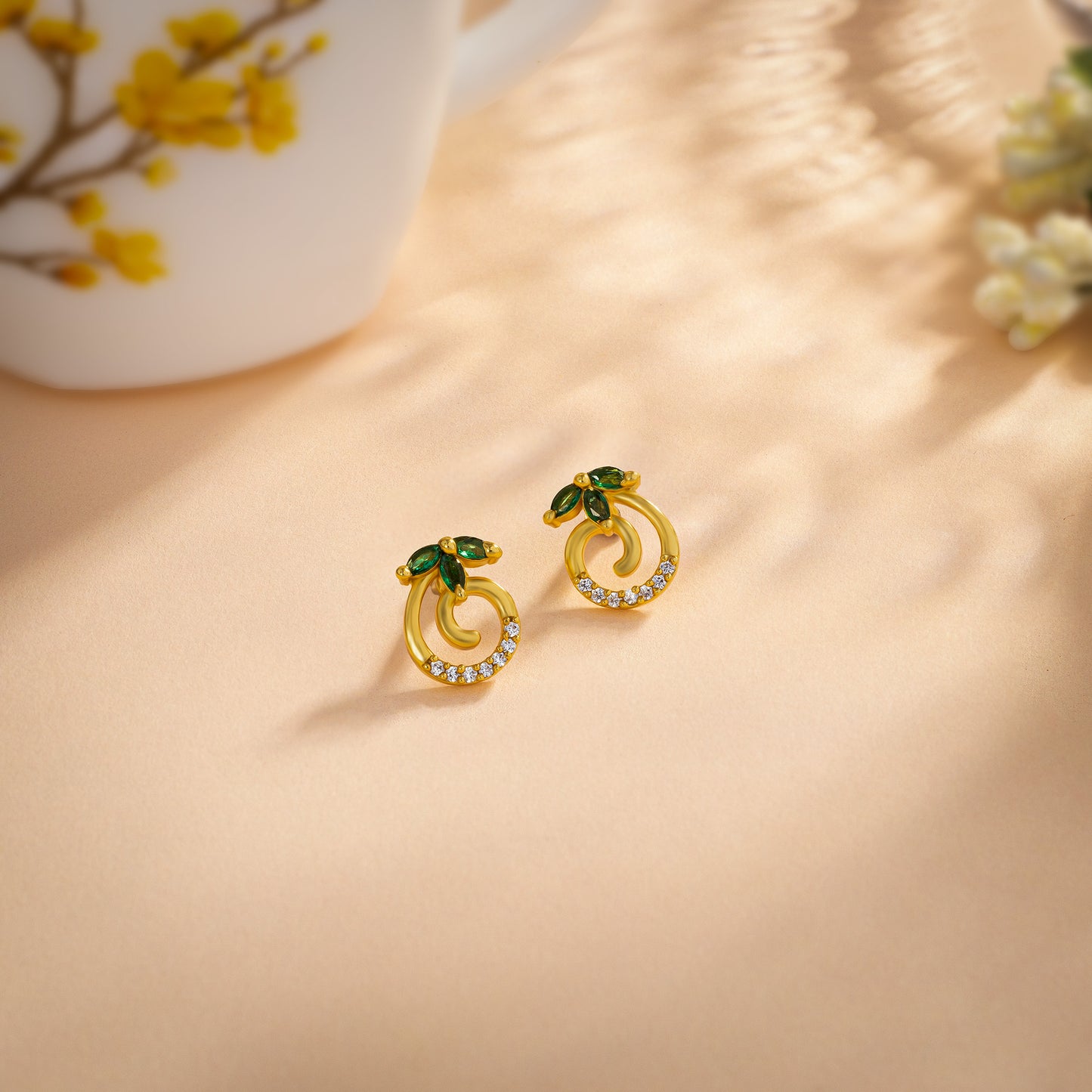 pair of golden earrings with emerald and diamonds