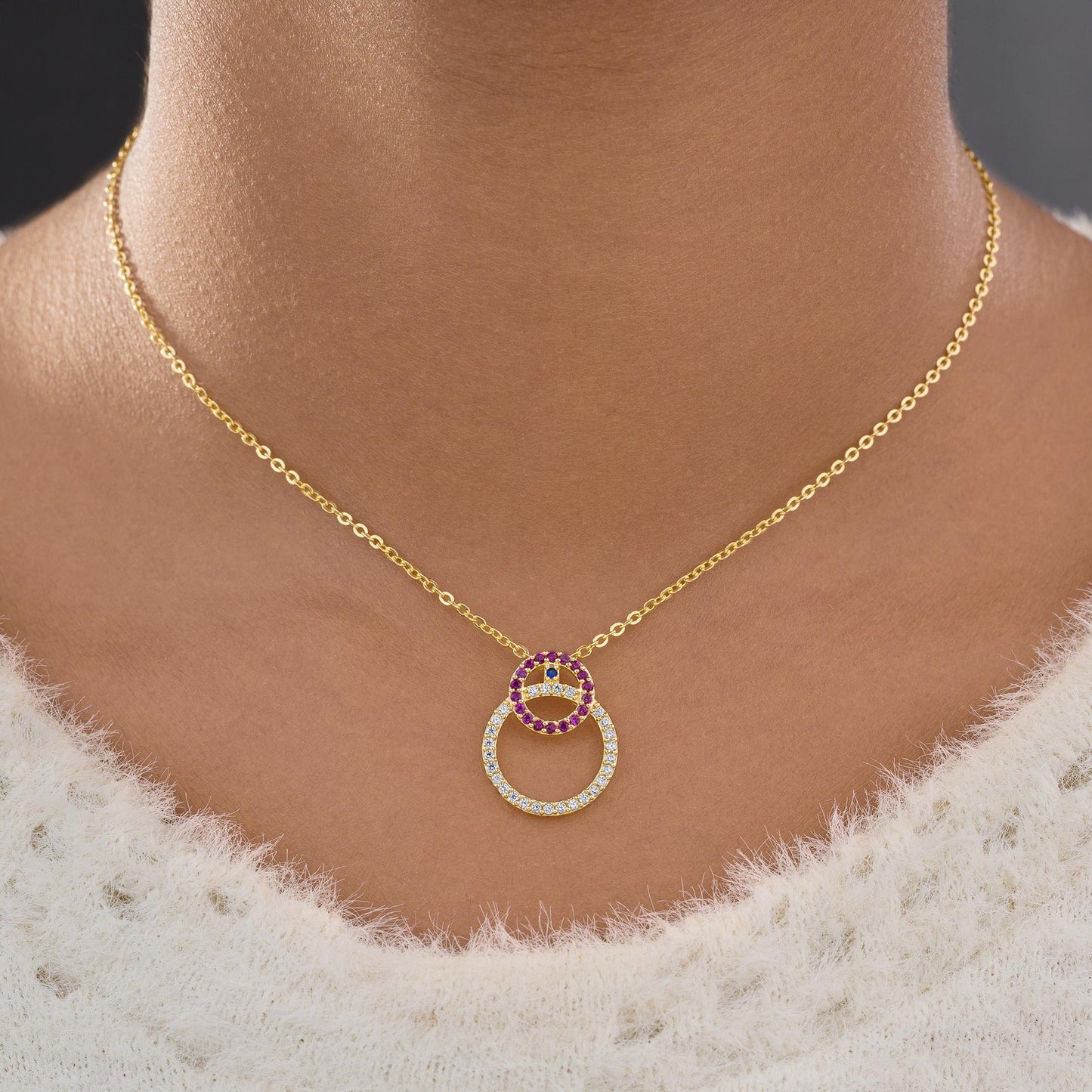 golden necklace with a diamond and ruby stone