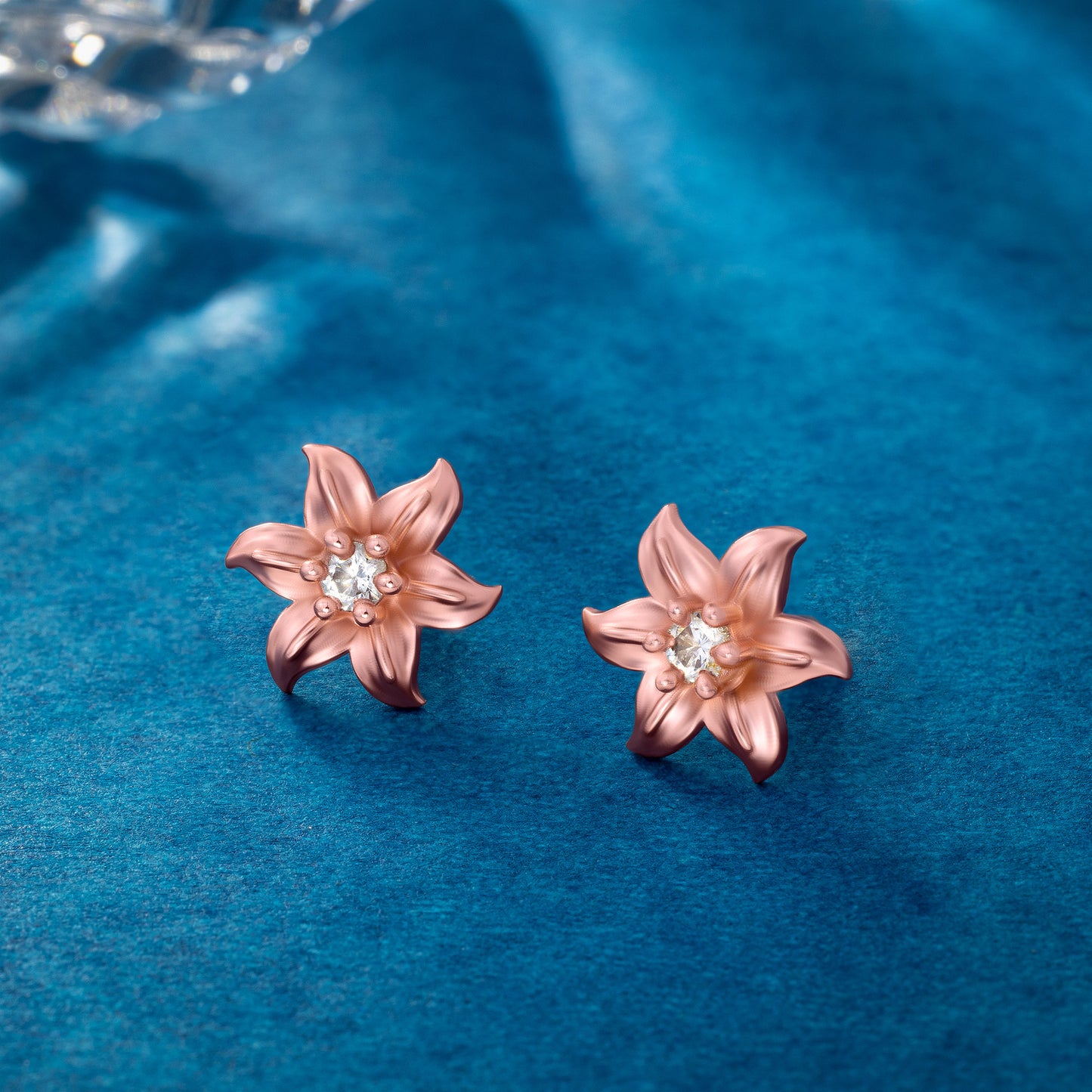 pair of rose gold earrings with white stones