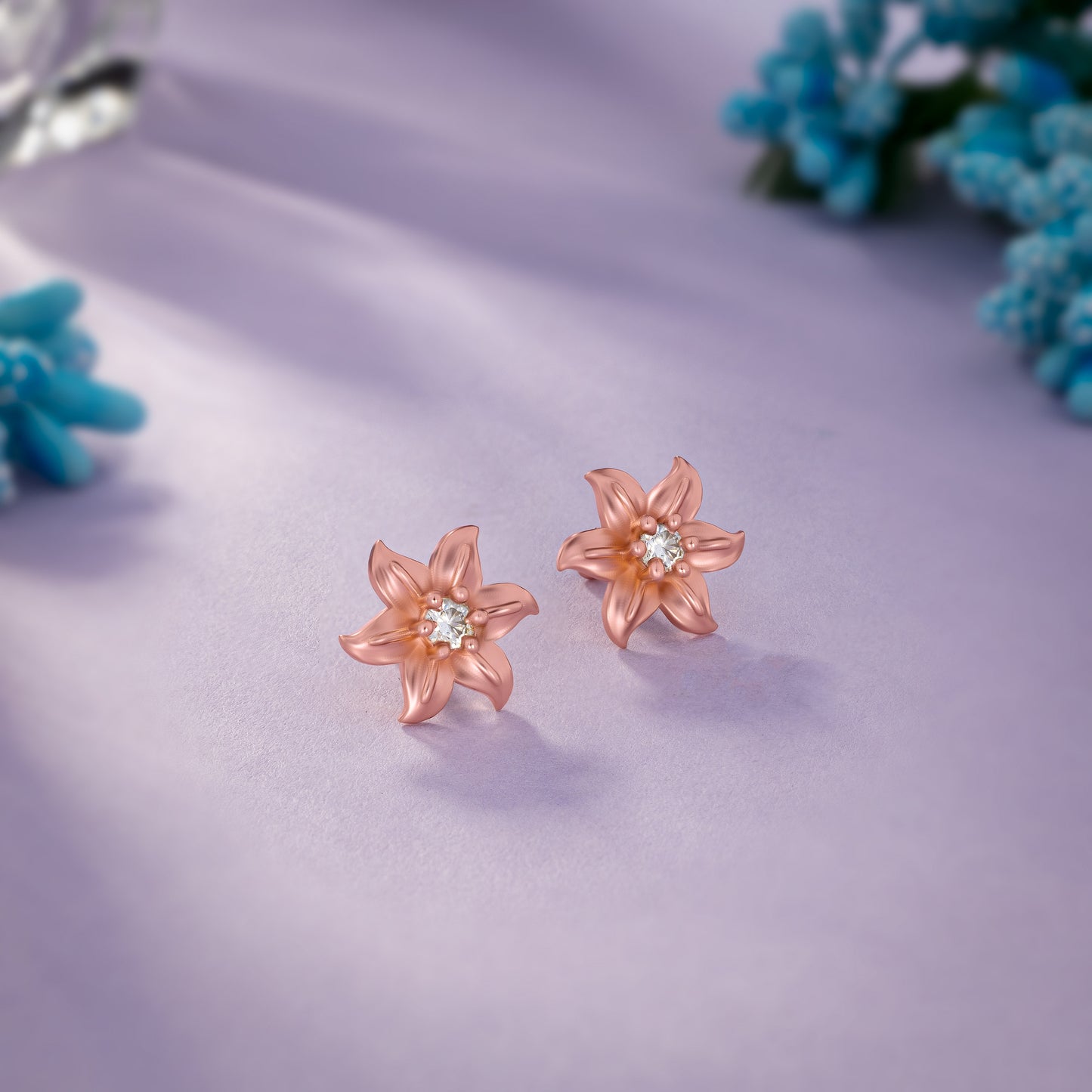 pair of rose gold earrings with white stones